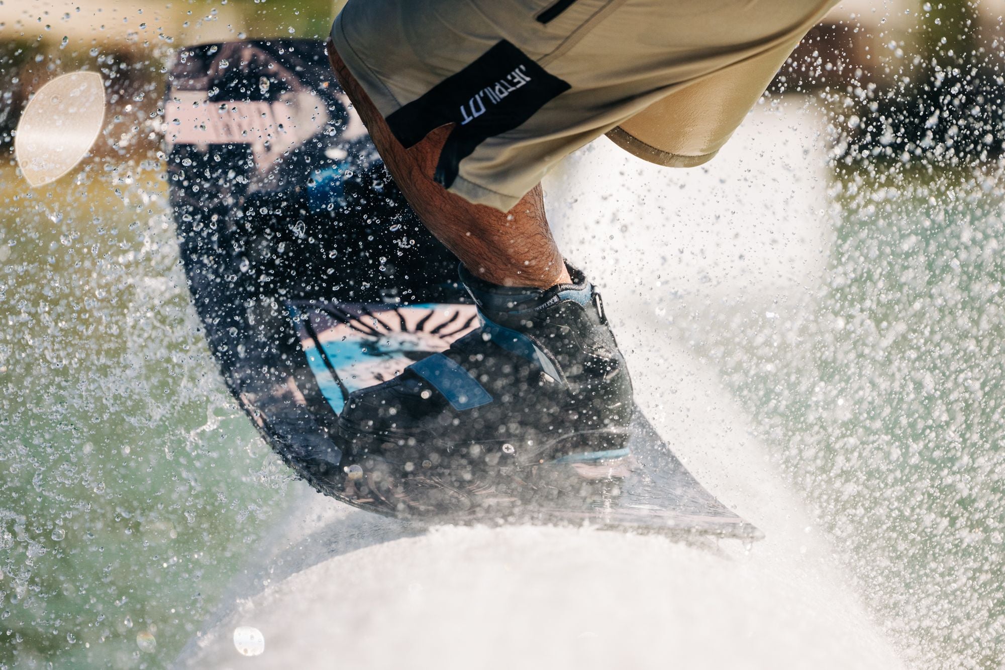 A person expertly maneuvering through the water waves with splashes all around them, effortlessly riding their reliable Liquid Force 2025 Butterstick Pro Wakeboard.