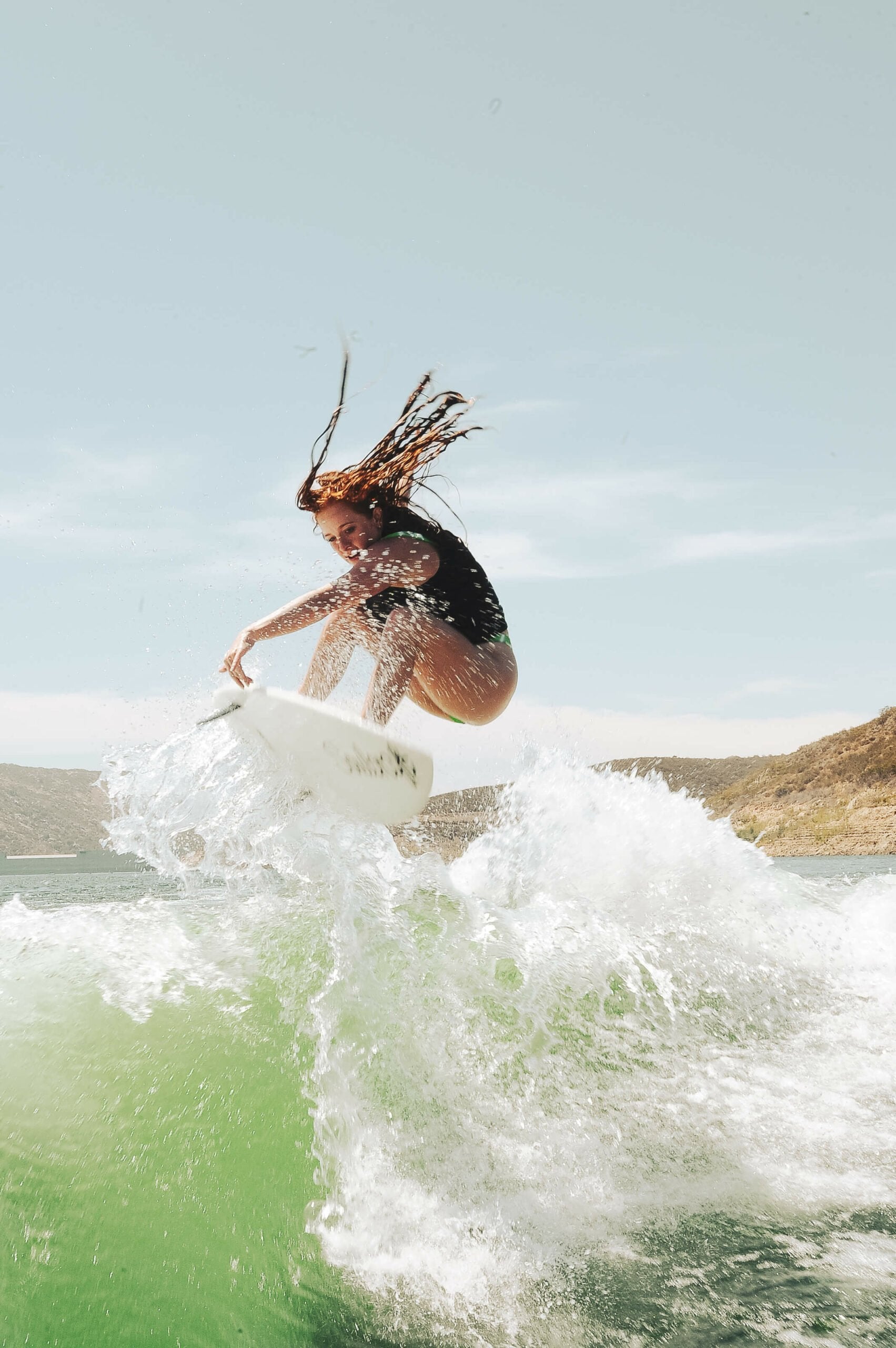 An intermediate rider is skillfully controlling the speed generation while riding a wave on a Soulcraft Control Freak Wakesurf Board.