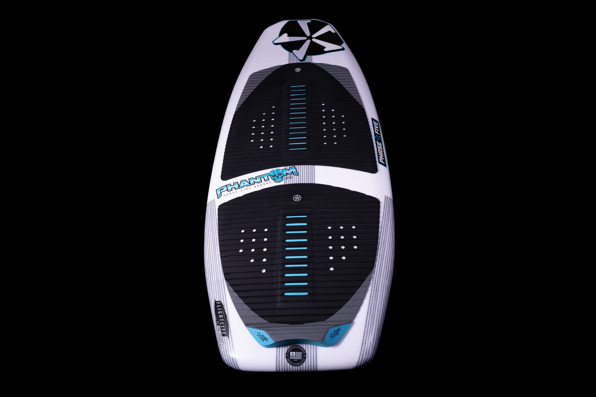 A top view of the Phase 5 2025 Phantom Wakesurf Board, featuring a sleek design with black and white elements and blue Flightlite V2 accents, set against a black backdrop.