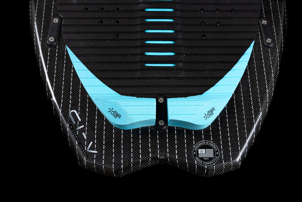 Close-up of the Phase 5 Hypsta v2 Wakesurf Board 2026 tail: textured black finish, white grid lines, blue traction pads, visible screws, TRI-Fin setup, Phase 5 branding, and a circular label with text and a QR code.