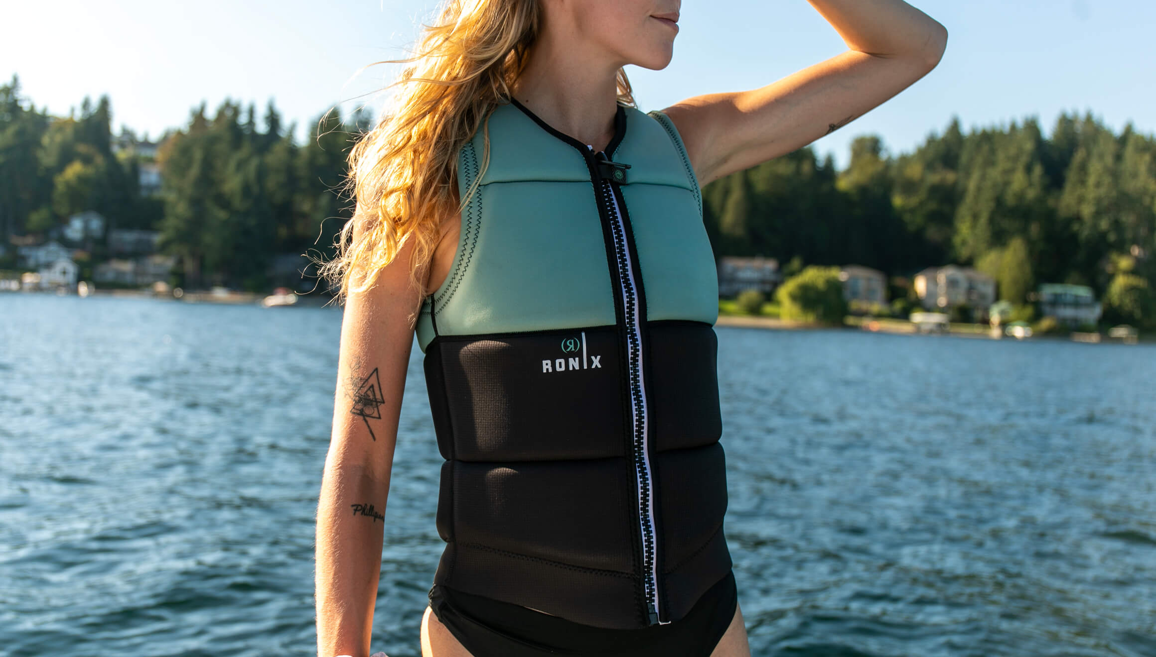 A woman wearing a Ronix 2024 Avalon Women's CE Impact Vest on a boat.