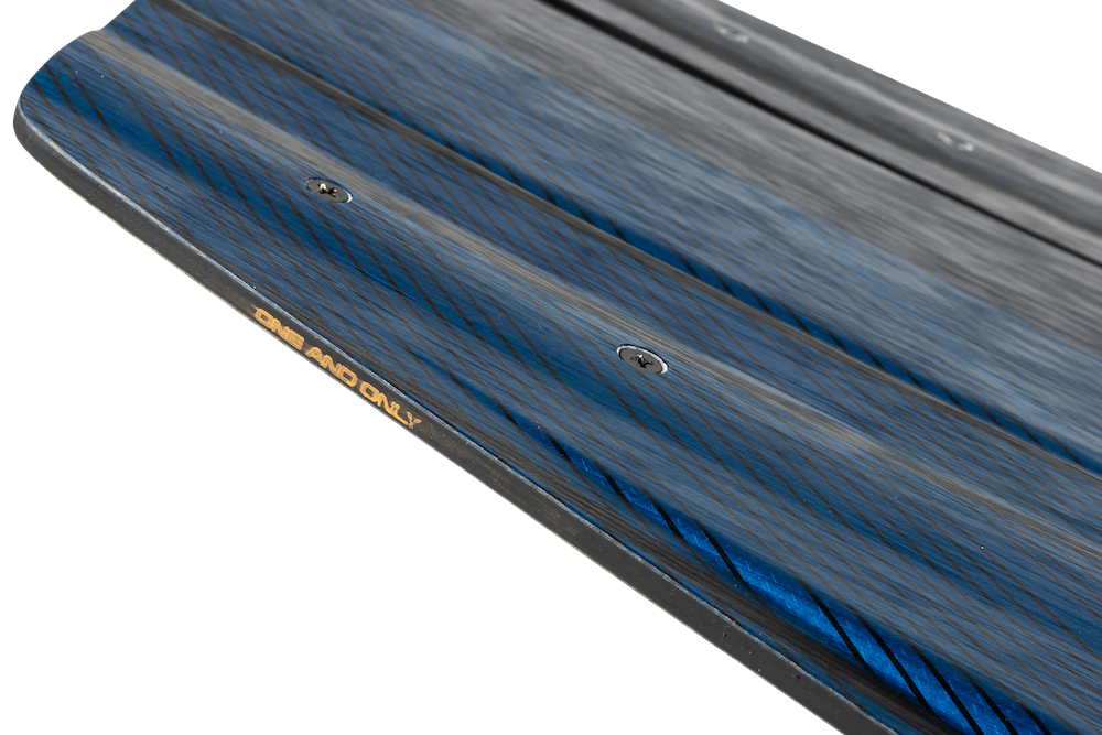 A close-up of the Ronix 2025 One Blackout Wakeboard reveals a detailed wood grain pattern and small screws on its surface, enhanced by Pre-Tension Glass technology for added stability.