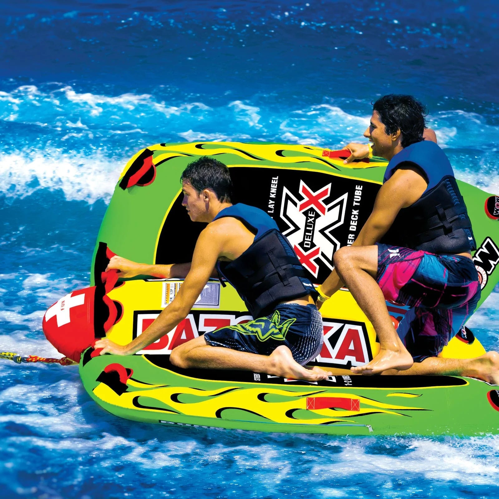 Two people on a green and yellow inflatable tube in the water with a visible brand logo.