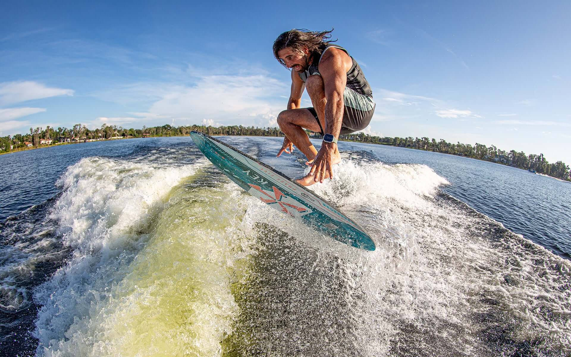 An advanced Phase 5 2024 Key Wakesurf Board riding a water ski on a lake.