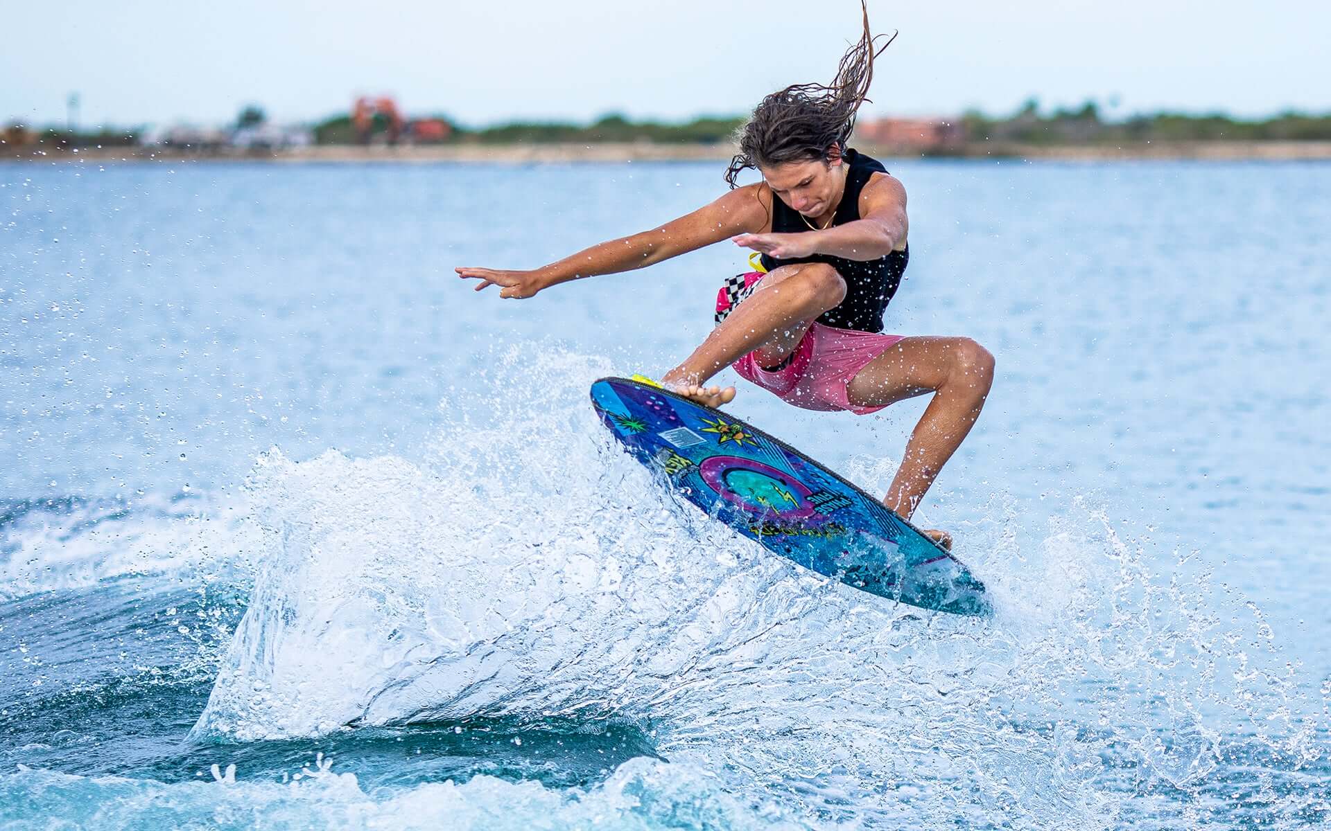 A man is riding a wave on a surfboard with a Phase 5 2024 Key Jett Shreds Wakesurf Board.