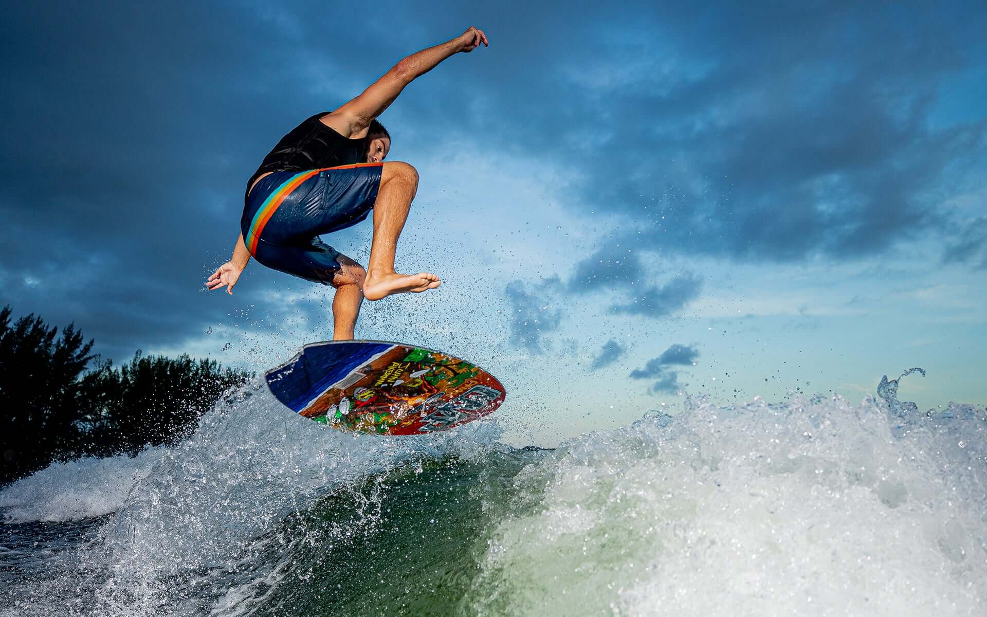 A man is riding a wave on a Phase 5 2024 MVP LTD Wakesurf Board, achieving an impressive skim style riding experience.