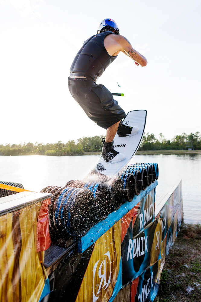 Massi, a lightweight and flexible man, is riding a Ronix 2024 RXT BOA Boots on a ramp.