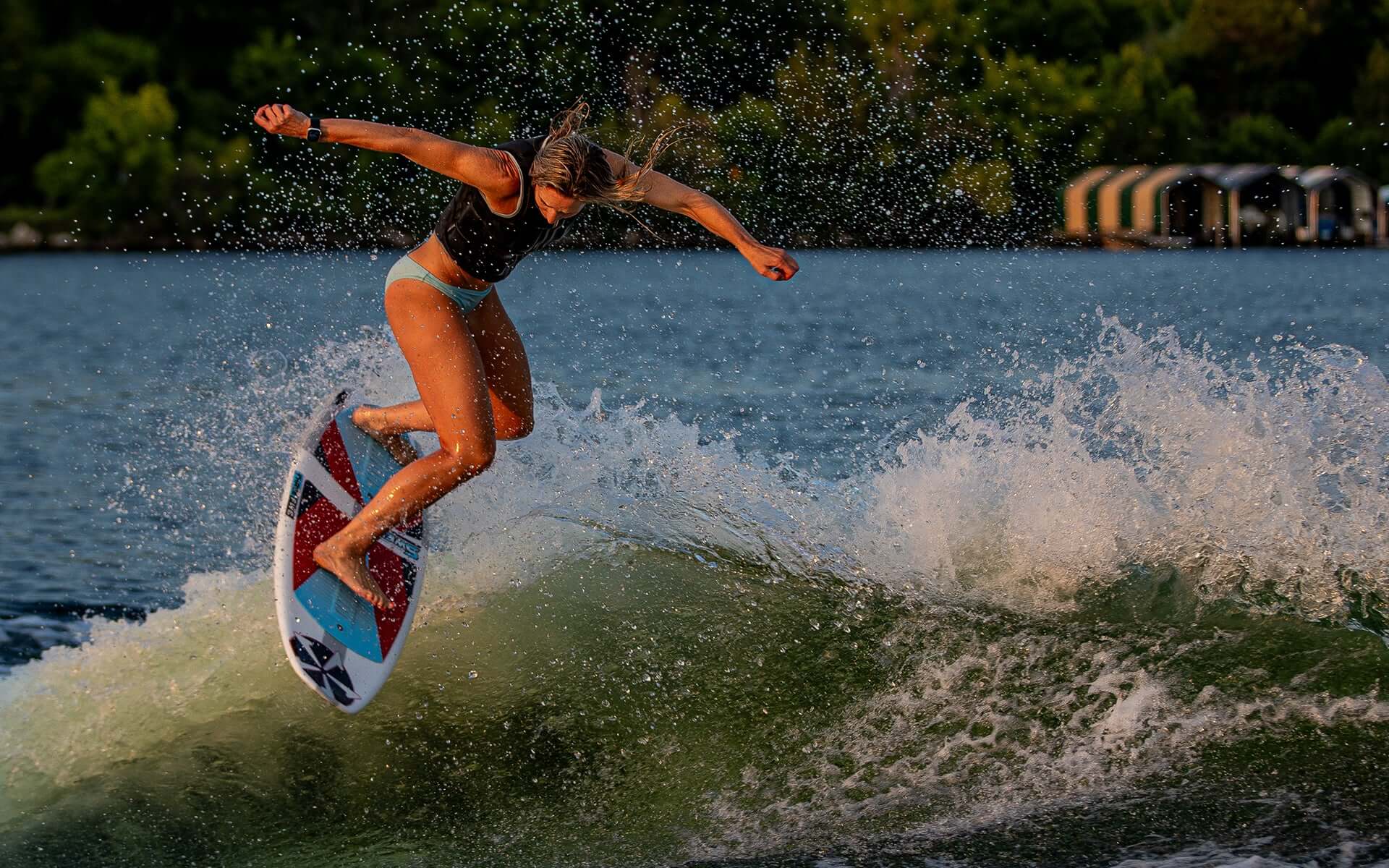 Stacia Bank, a high-performance surfer, is riding a wave on a Phase 5 2024 Swell Wakesurf Board.