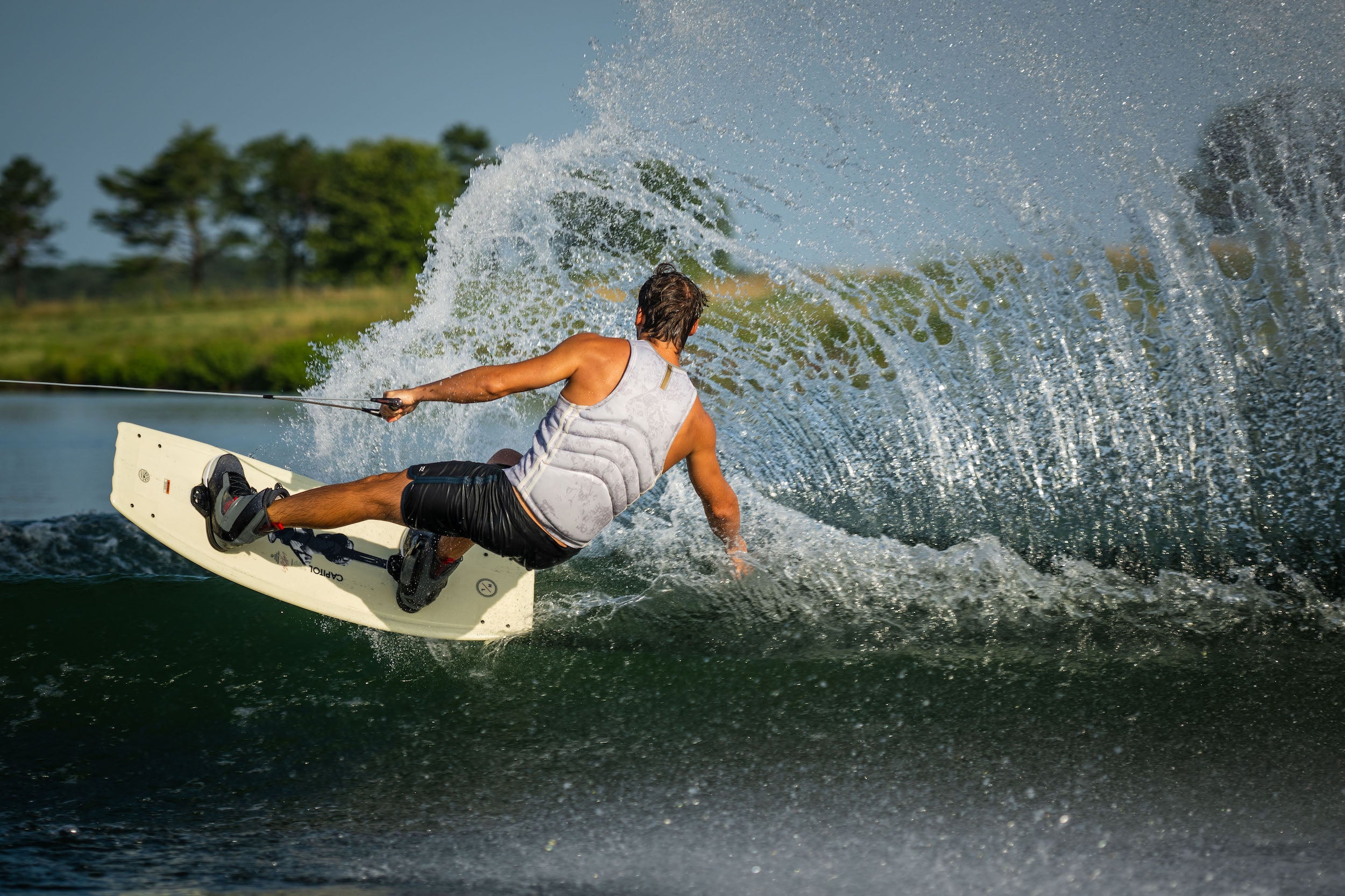 Cory Teunissen, a skilled wakeboarder, expertly maneuvers on a Hyperlite 2023 Capitol Wakeboard at Capitol Wakeboard.