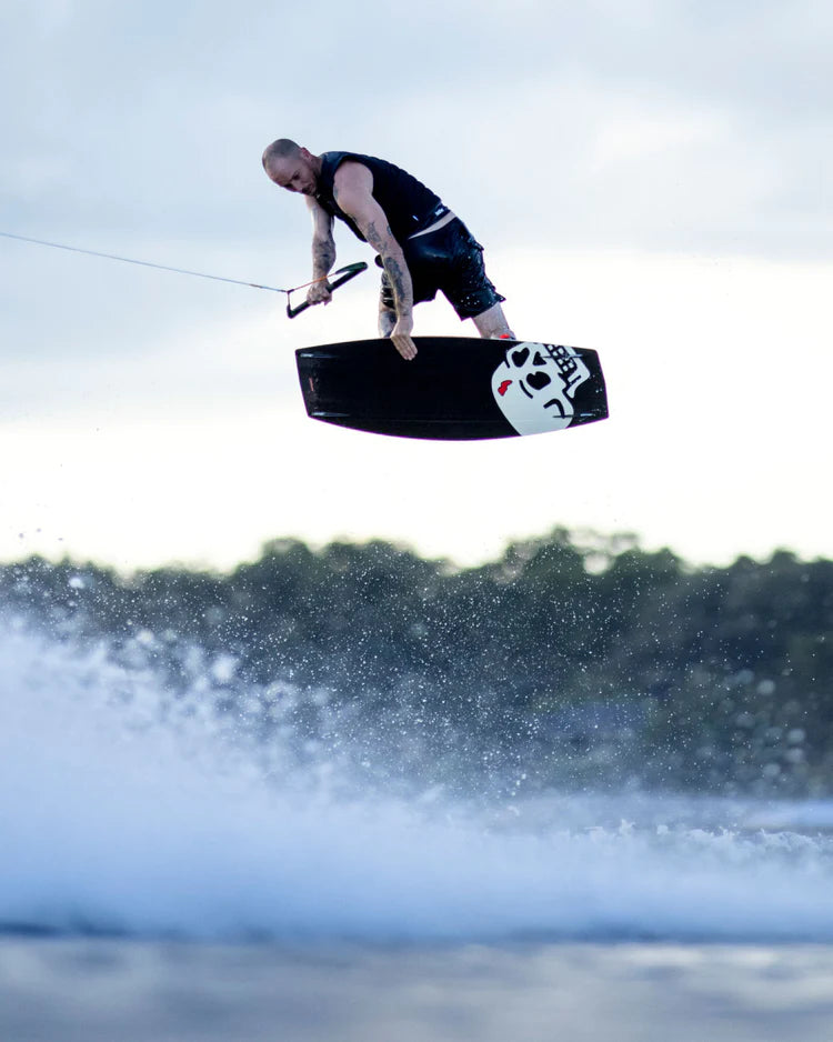 A man effortlessly wakeboarding in the air, experiencing comfortable and durable impact protection over a body of water wearing the Follow 2022 BP Pro Men's Jacket by Follow Wake - Black.