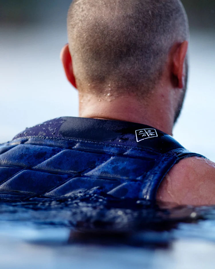 The back of a man wearing a Follow Wake 2022 BP Pro Men's Jacket - Navy in the water, providing impact protection.