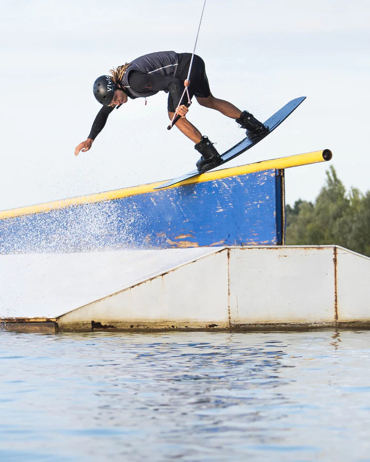 A person on a water ski performing a thrilling trick while sporting the cutting-edge Follow Wake 2022 F#*FED Men's Jacket - Black Quad-S© Neo gear.