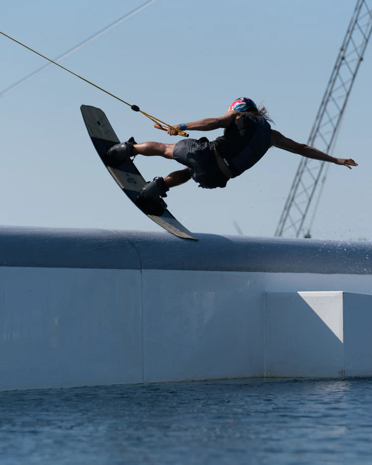A person performing a gravity-defying trick on a water board, showcasing their remarkable balance and agility while wearing the Follow 2022 Unity Men's Jacket - Black from Follow Wake.