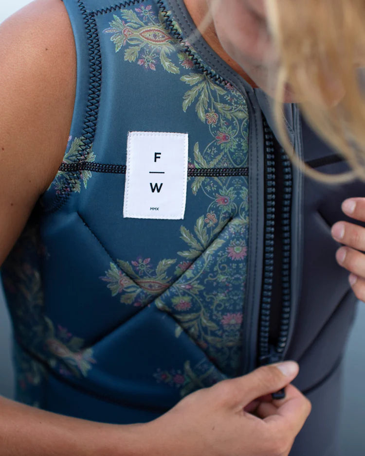 A woman wearing a Follow Wake neoprene vest with a label on it.