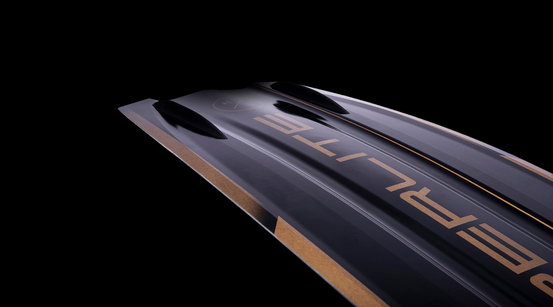 A close up of a Hyperlite 2023 Rusty Pro Wakeboard with a black and gold design, giving a poppy feel.