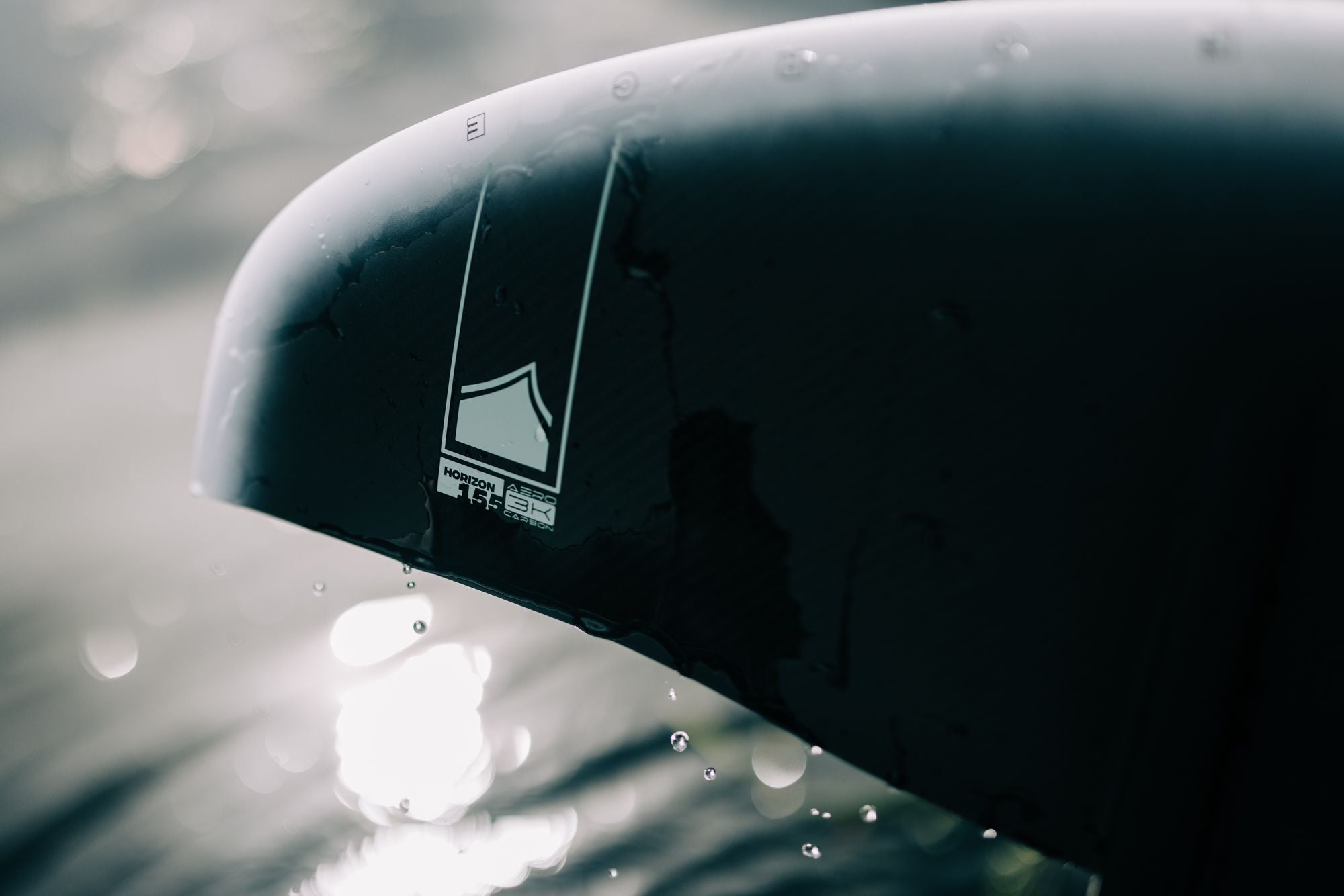 A black Liquid Force car with a Liquid Force 2024 Horizon Surf 155 Front Wing logo on the side of it.
