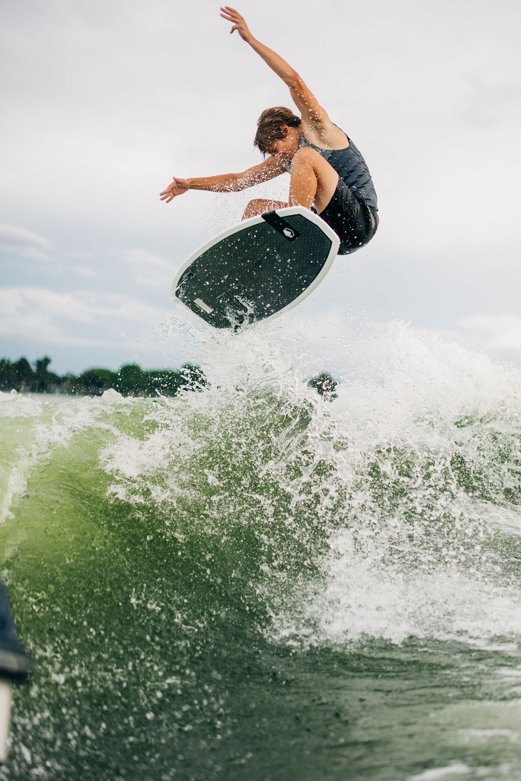 A lightweight man riding a wave on a Liquid Force 2024 Quest Wakesurf Board with lightning speed.