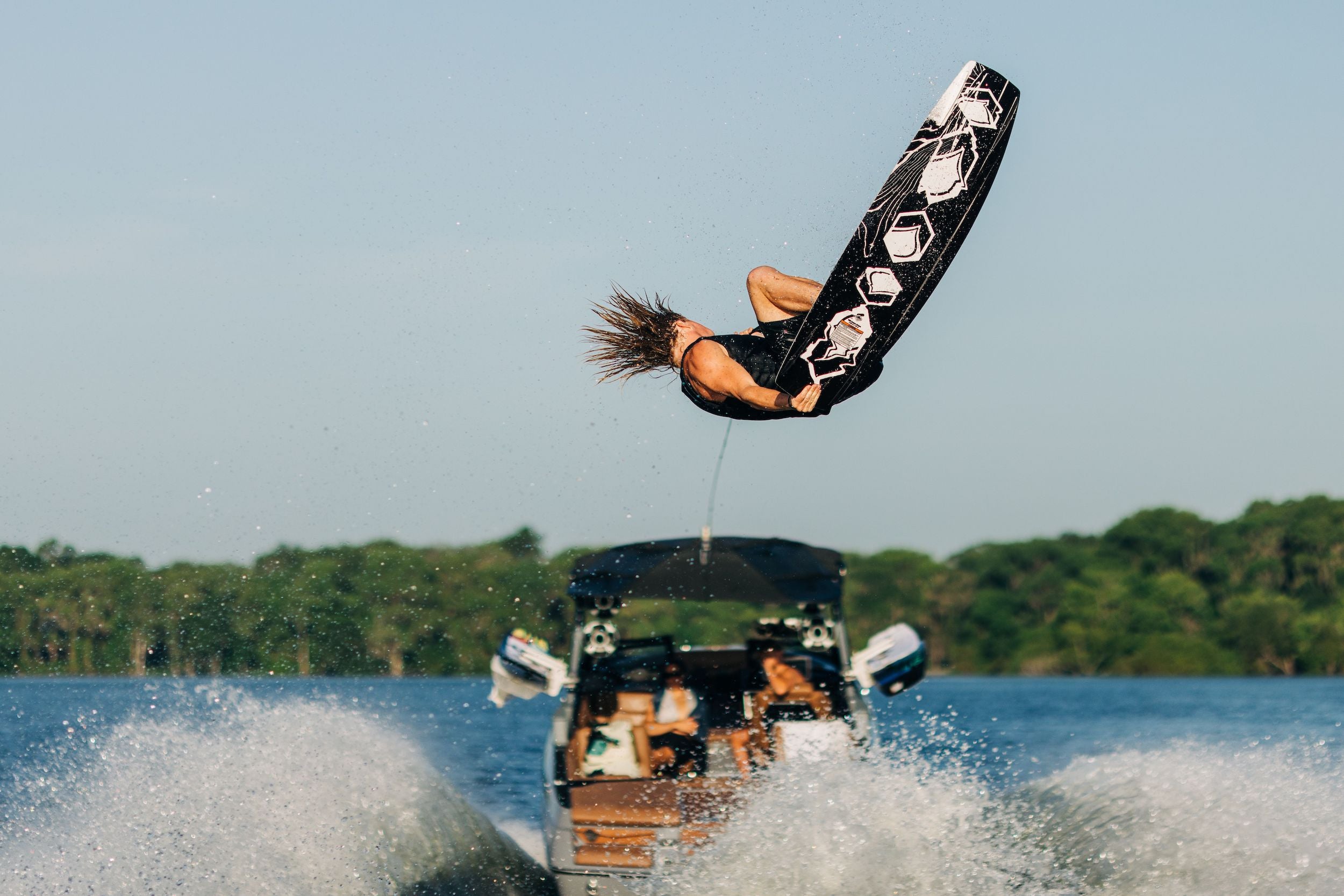 A person performing a smooth and controlled ride on a Liquid Force 2024 RDX Wakeboard equipped with quad molded-in fins.