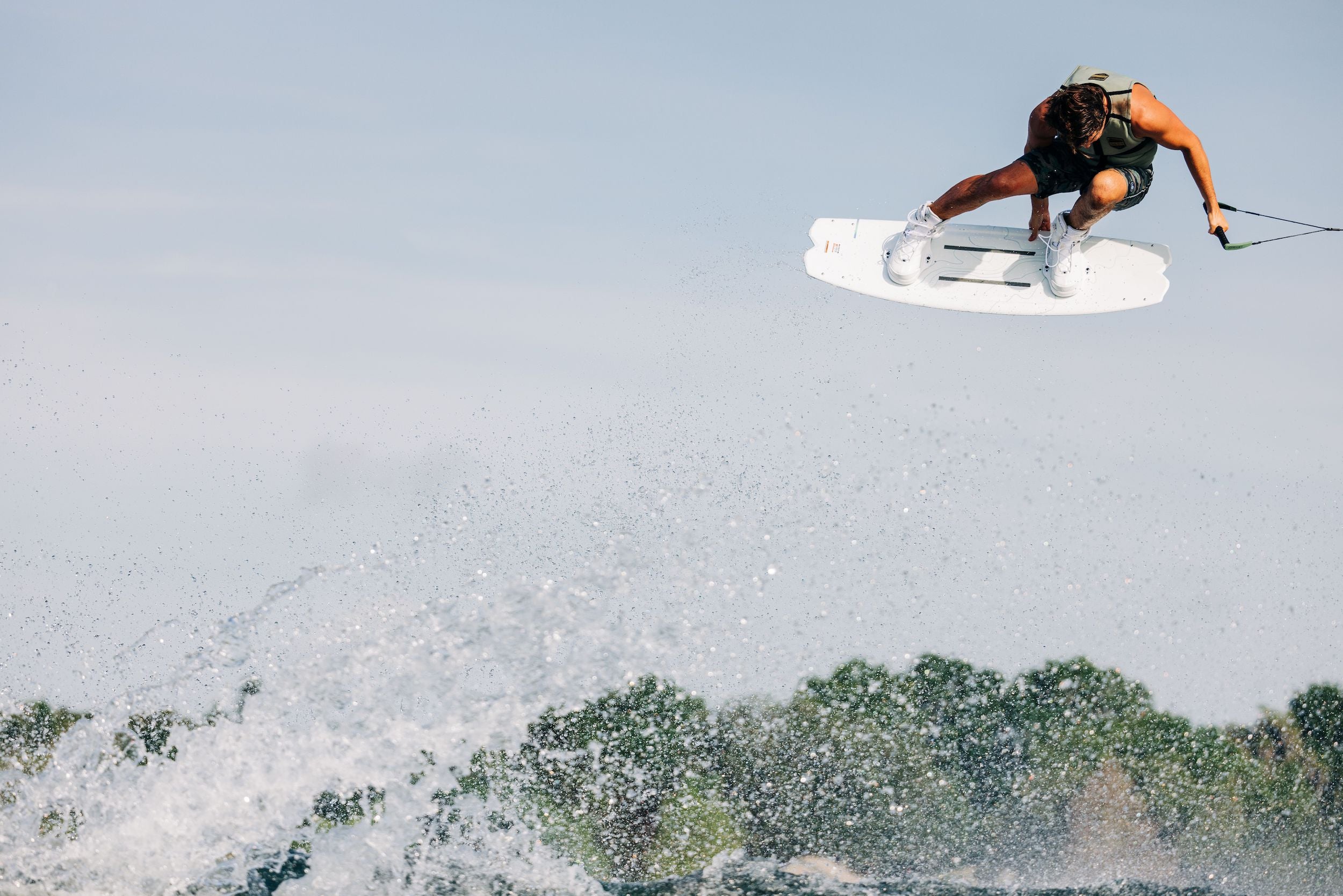 Harley Clifford, a professional wakeboarder, is effortlessly soaring through the air on his Liquid Force 2023 Remedy Aero wakeboard. This high-performance board is not only lightweight but also provides him with the perfect balance and stability for executing tricks.
