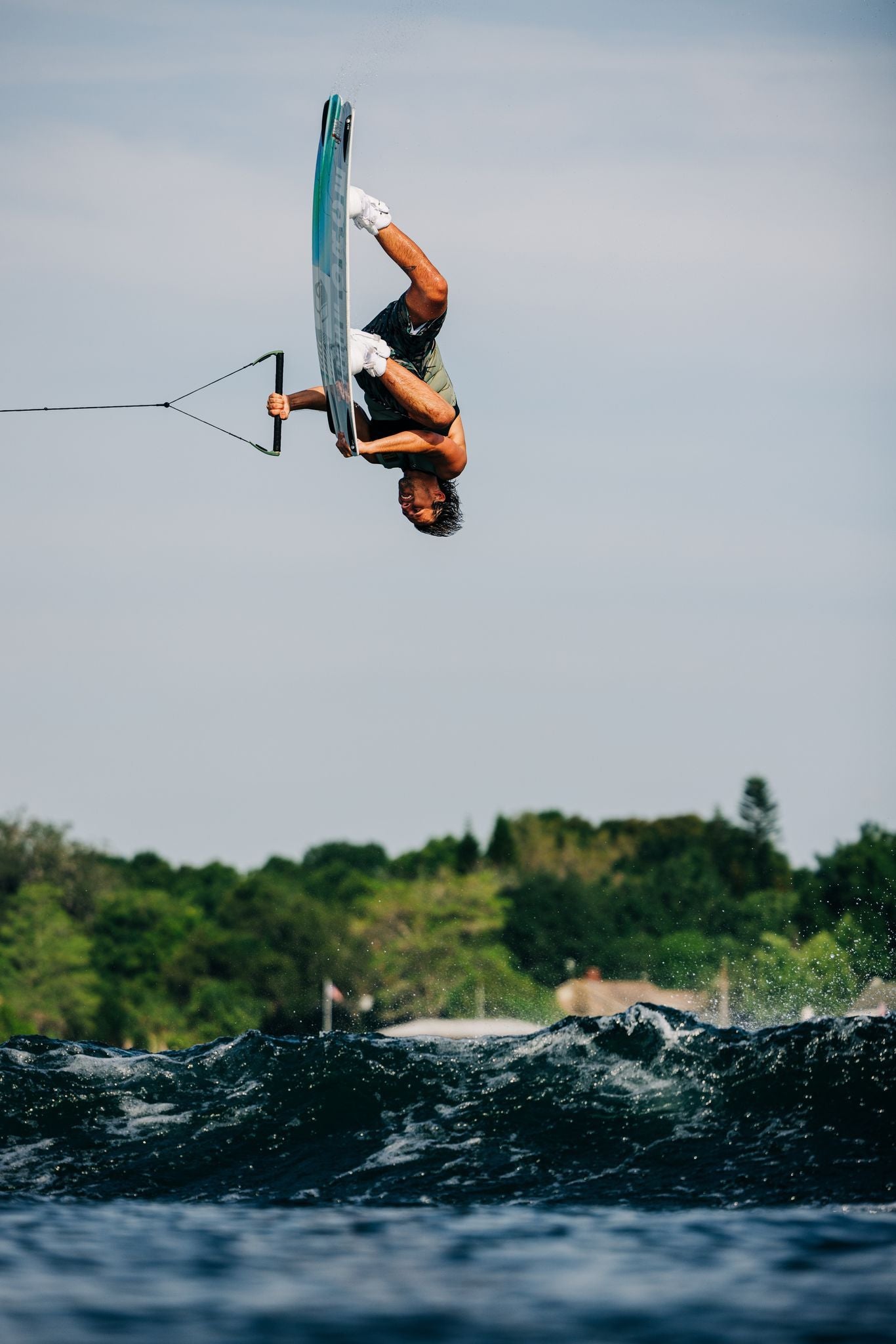 Harley Clifford, a lightweight wakeboarder, showcasing his skills and performing tricks in the water while using the Liquid Force 2023 Remedy Aero Wakeboard board.