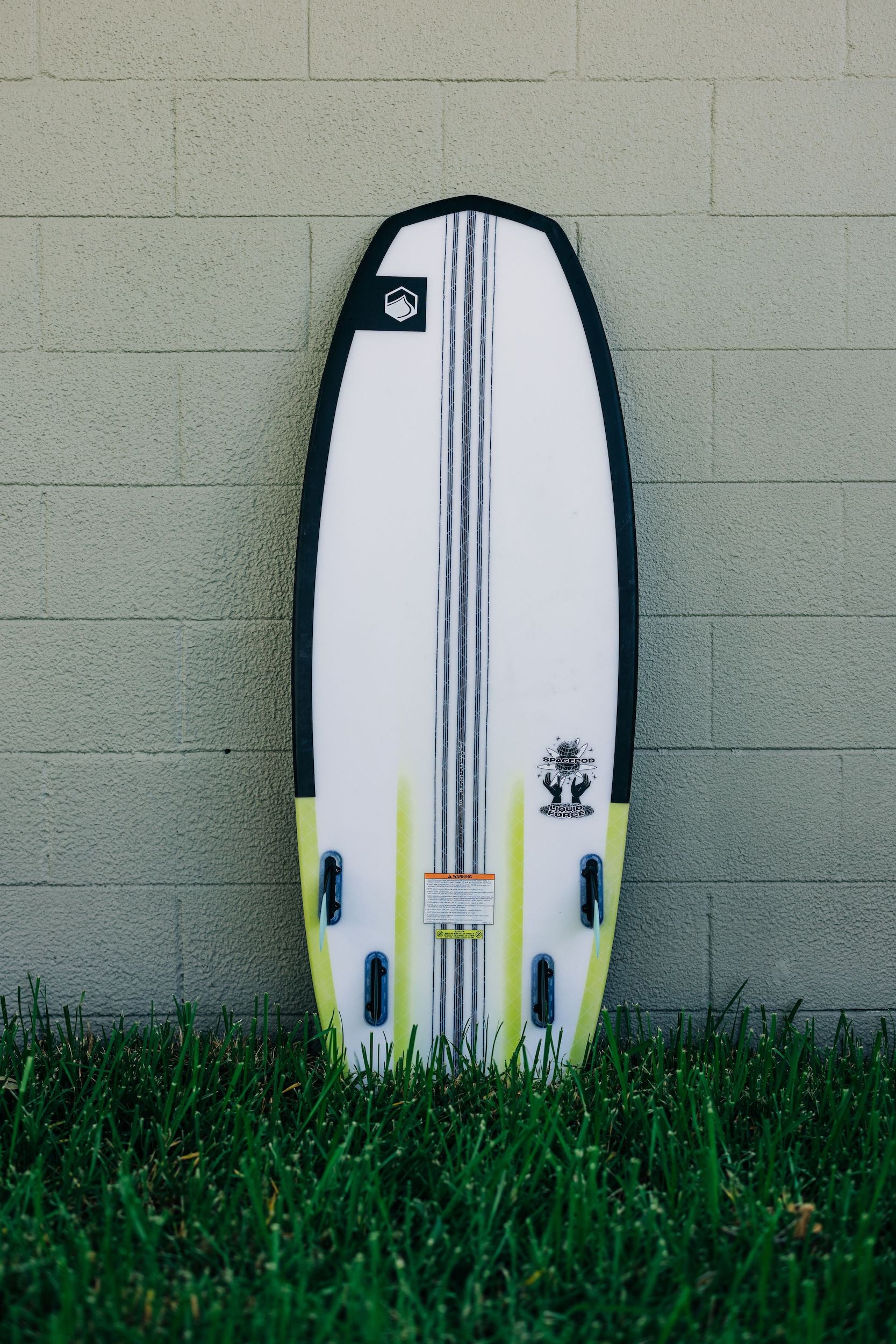 A Liquid Force 2023 Space Pod Wakesurf Board leaning against a wall, exhibiting exceptional maneuverability and performance.