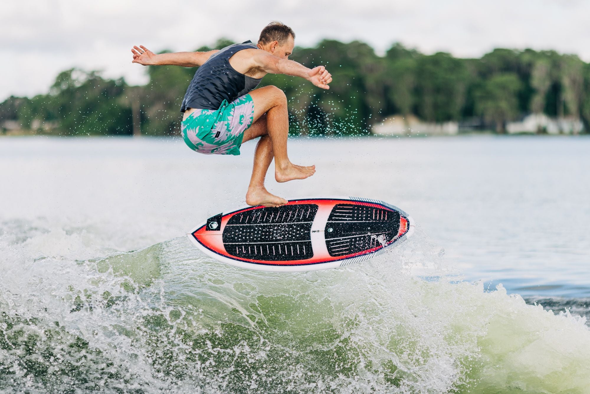 A man wakesurfing on a lightweight Liquid Force 2024 TC Skim Board wakeboard.