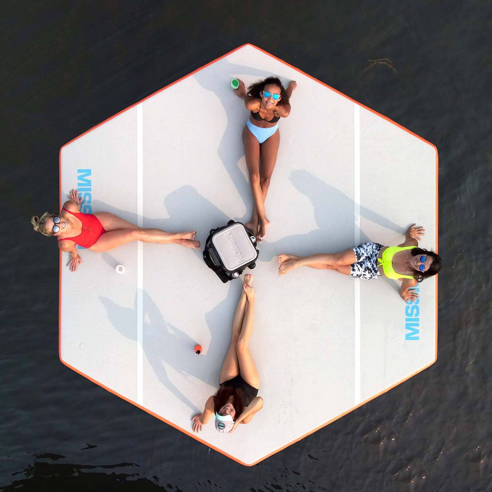 Four women enjoying a social life on a MISSION Reef Hex 112 Inflatable Water Mat (11.5' x 13' x 4") in the water.