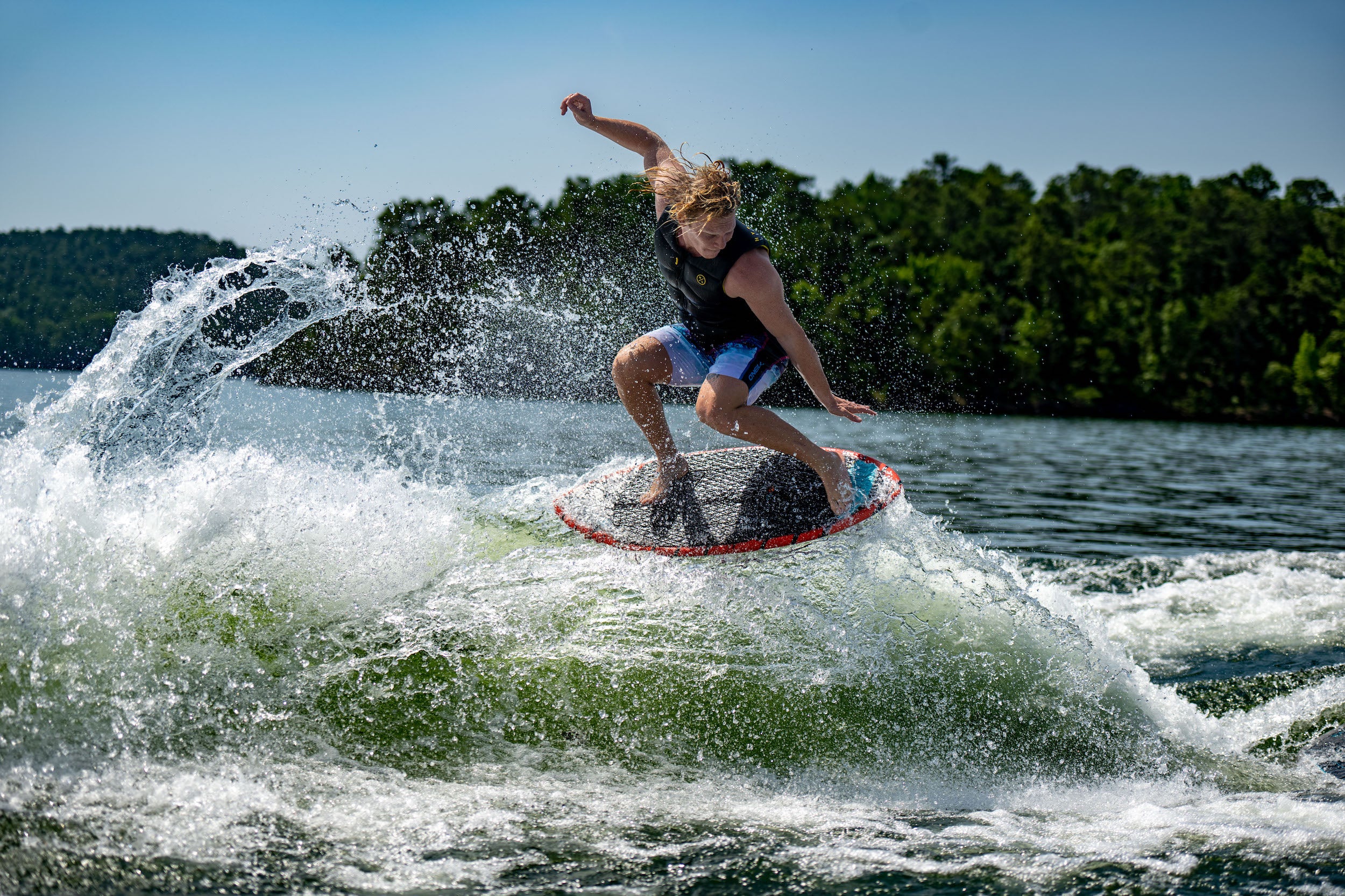 A man riding a wave on a Hyperlite 2023 Hi-Fi Wakesurf Board with DuraShell construction.