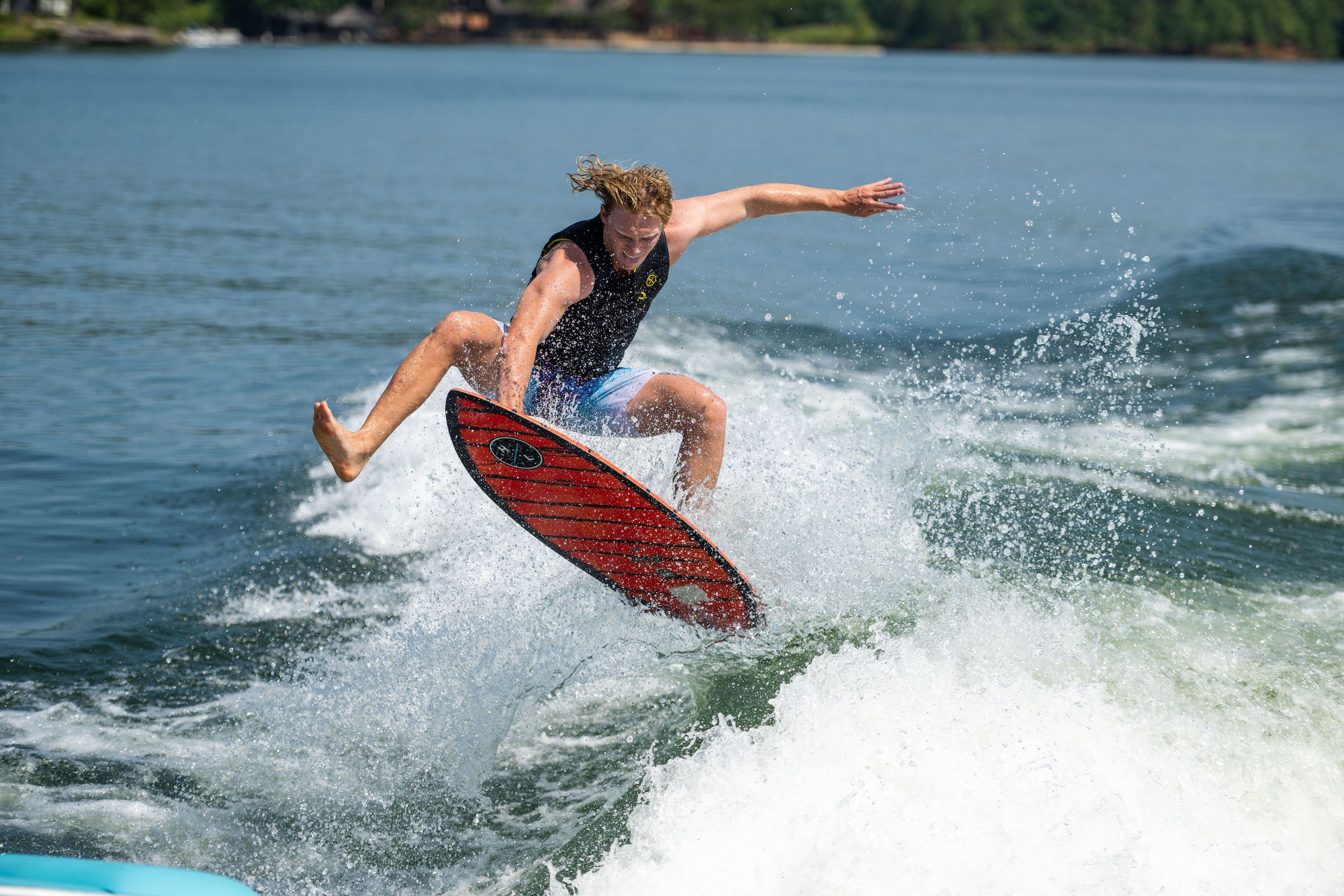 A man is riding a wave on a surfboard with Hyperlite 2023 Hi-Fi Wakesurf Board features.