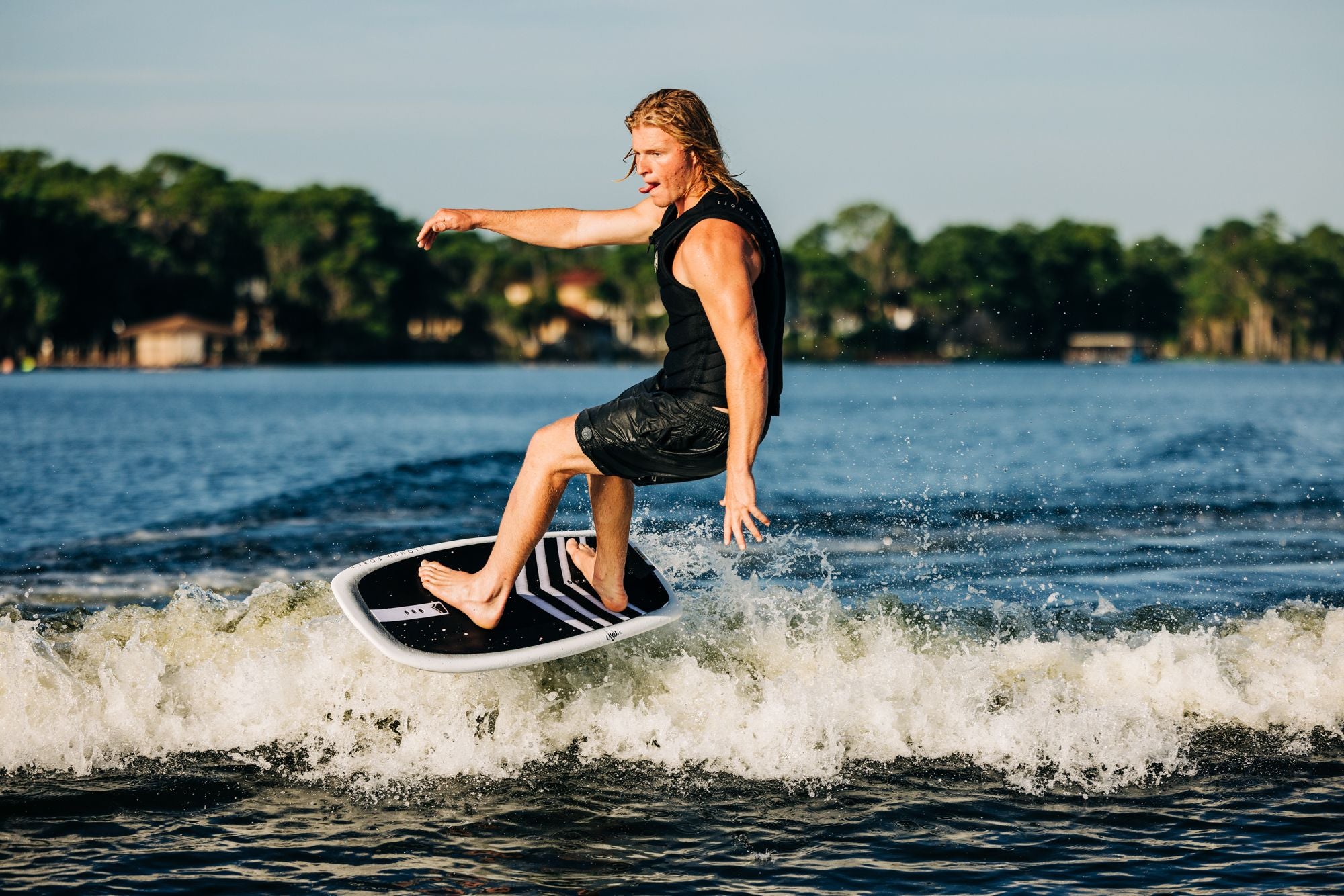 A man riding a Liquid Force 2024 Orb Foil Board wakeboard on a body of water.