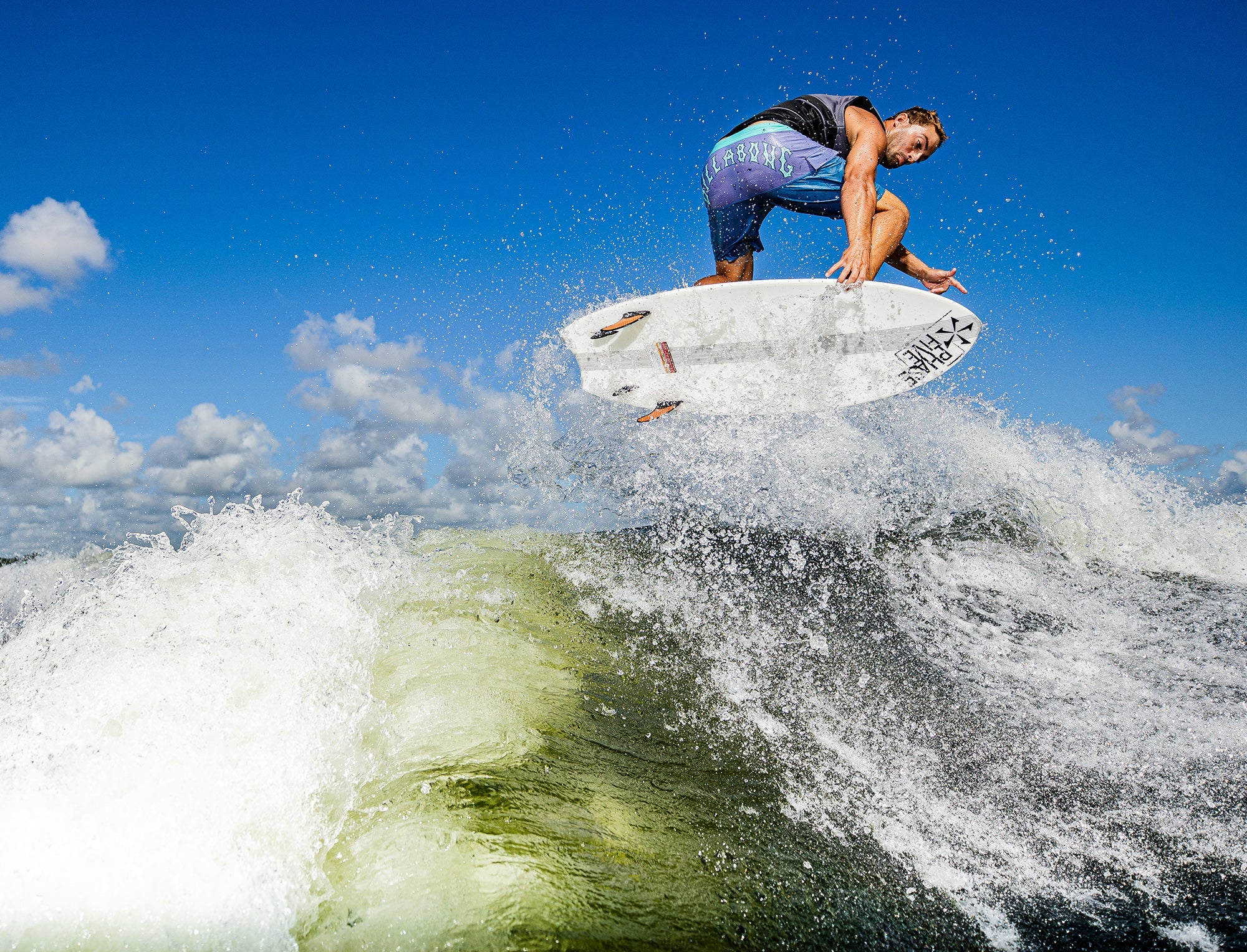A man is riding a wave on a Phase 5 2023 Ahi Wakesurf Board, produced by Phase 5.