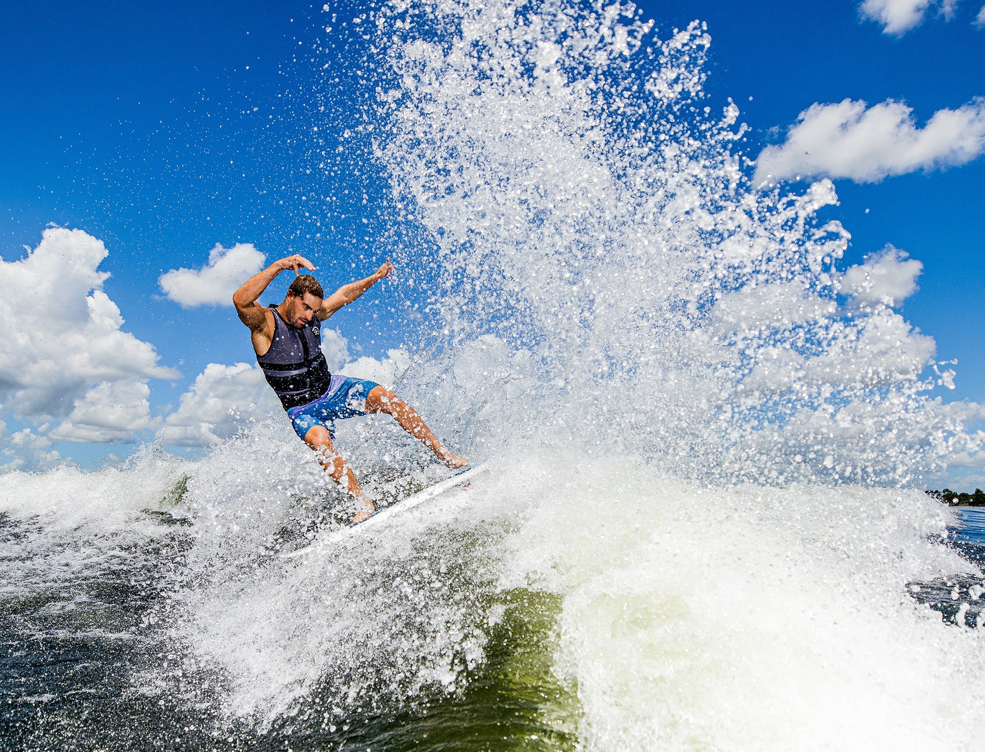 A man riding a wave on a Phase 5 2023 Ahi Wakesurf Board.
