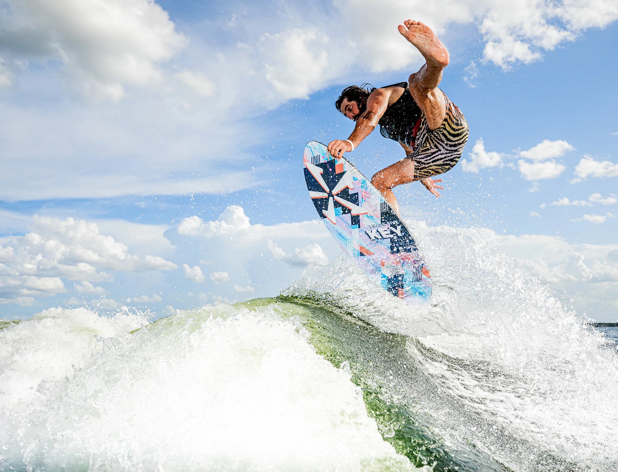 An advanced wakesurfer is riding a wave on a Phase 5 2023 Key Wakesurf Board, a skim style surfboard.