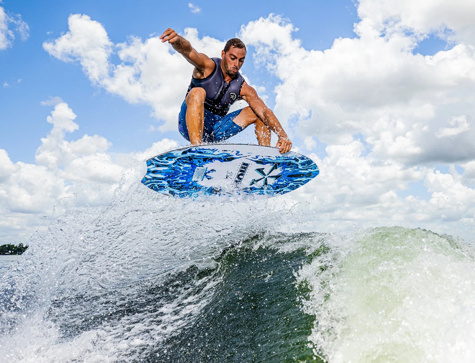 An impressive man performing skim style tricks on a Phase 5 2023 MVP Wakesurf Board in the air, showcasing his incredible Phase 5 talent.