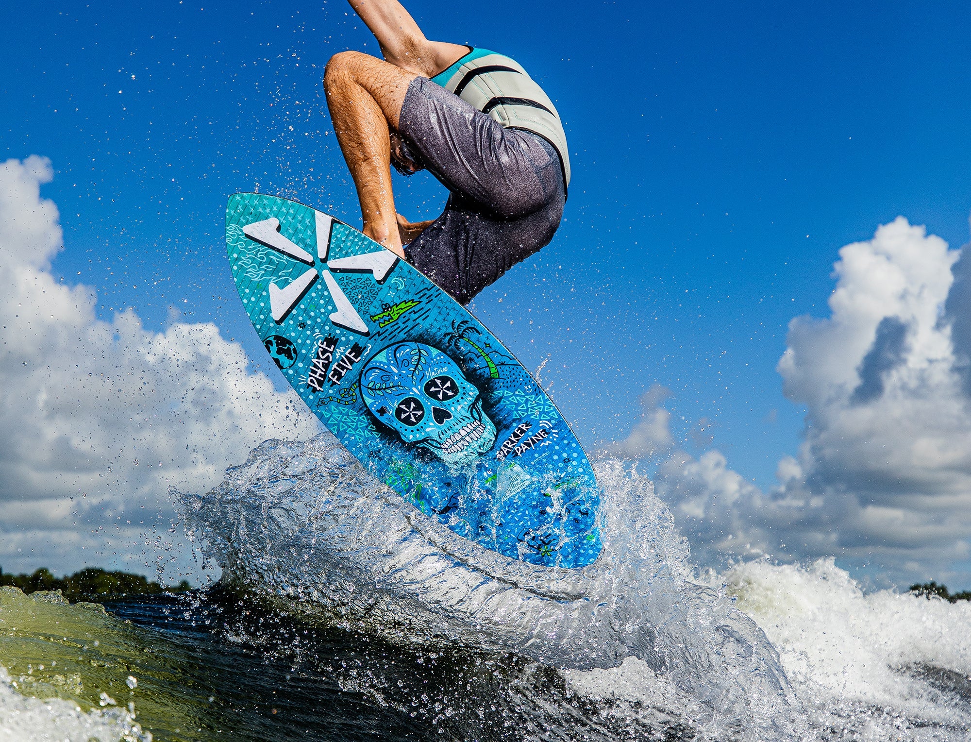 A man is riding a Phase 5 Matrix Payne Pro Wakesurf Board in the water, showcasing his impeccable Skim Style skills.