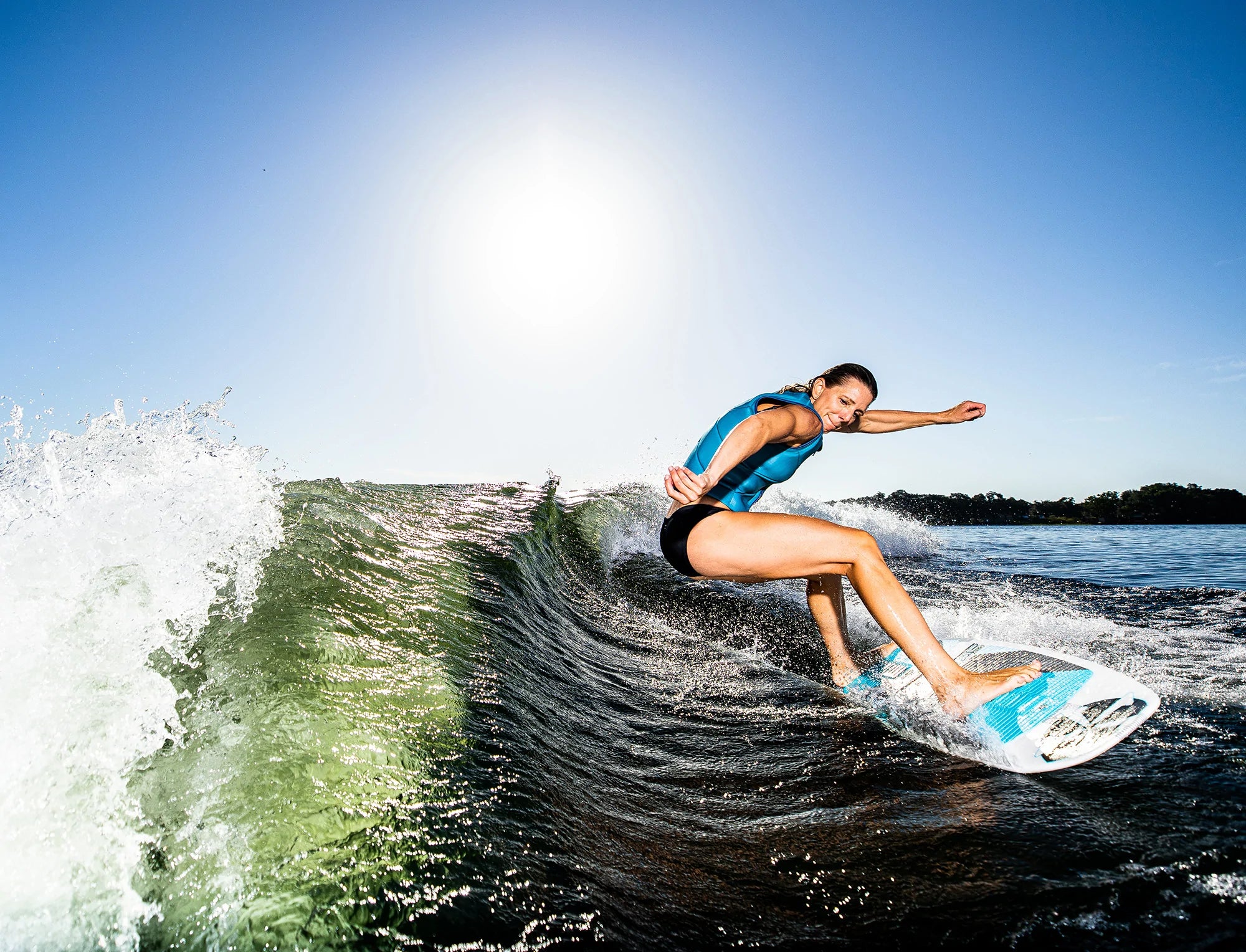 Stacia Bank effortlessly rides a wave on her Phase 5 2023 Swell Wakesurf Board, showcasing the incredible performance of FLEXtec V2.