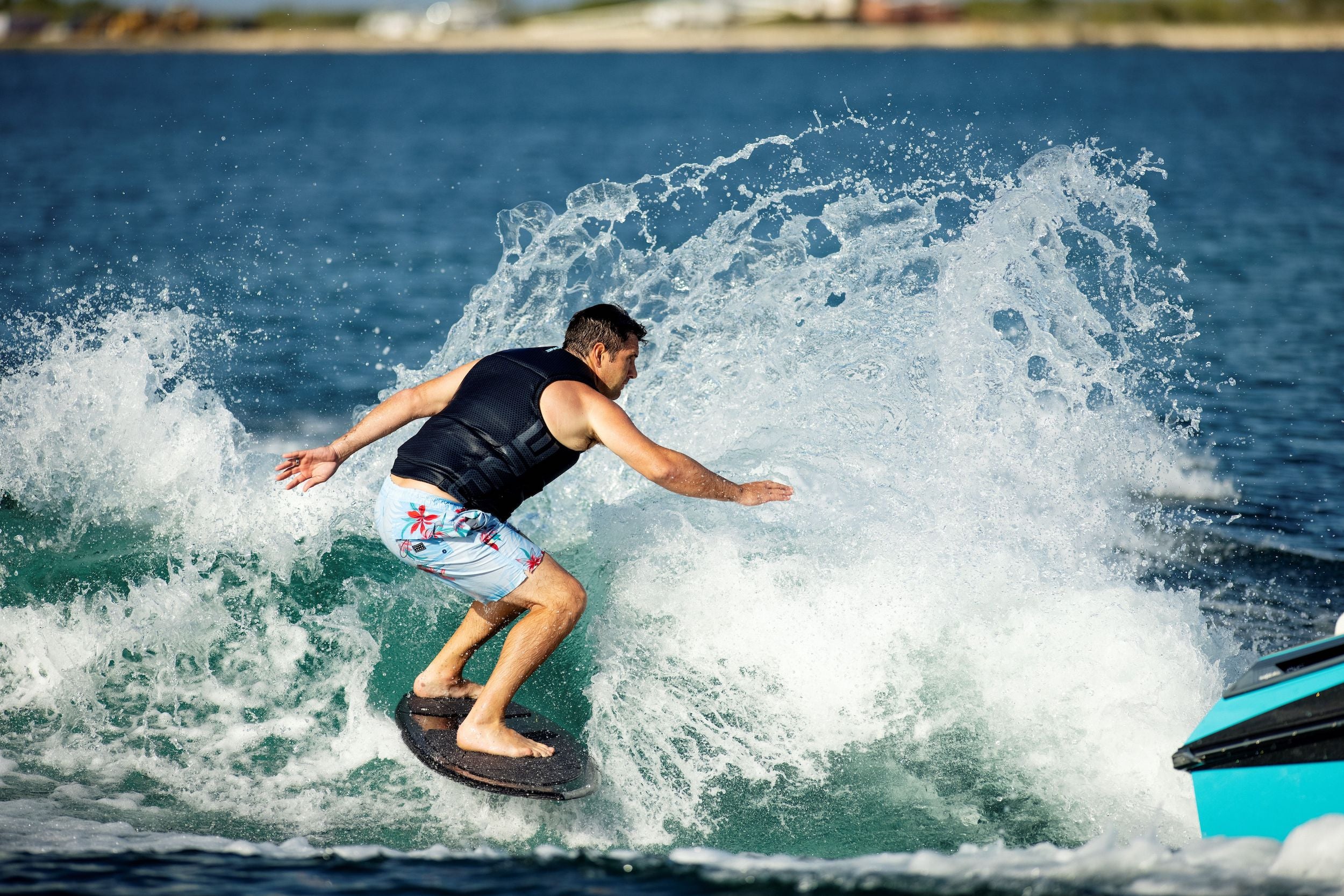 A man expertly riding a high-end, Ronix 2024 Carbon Air Core 3 wave skimmer.