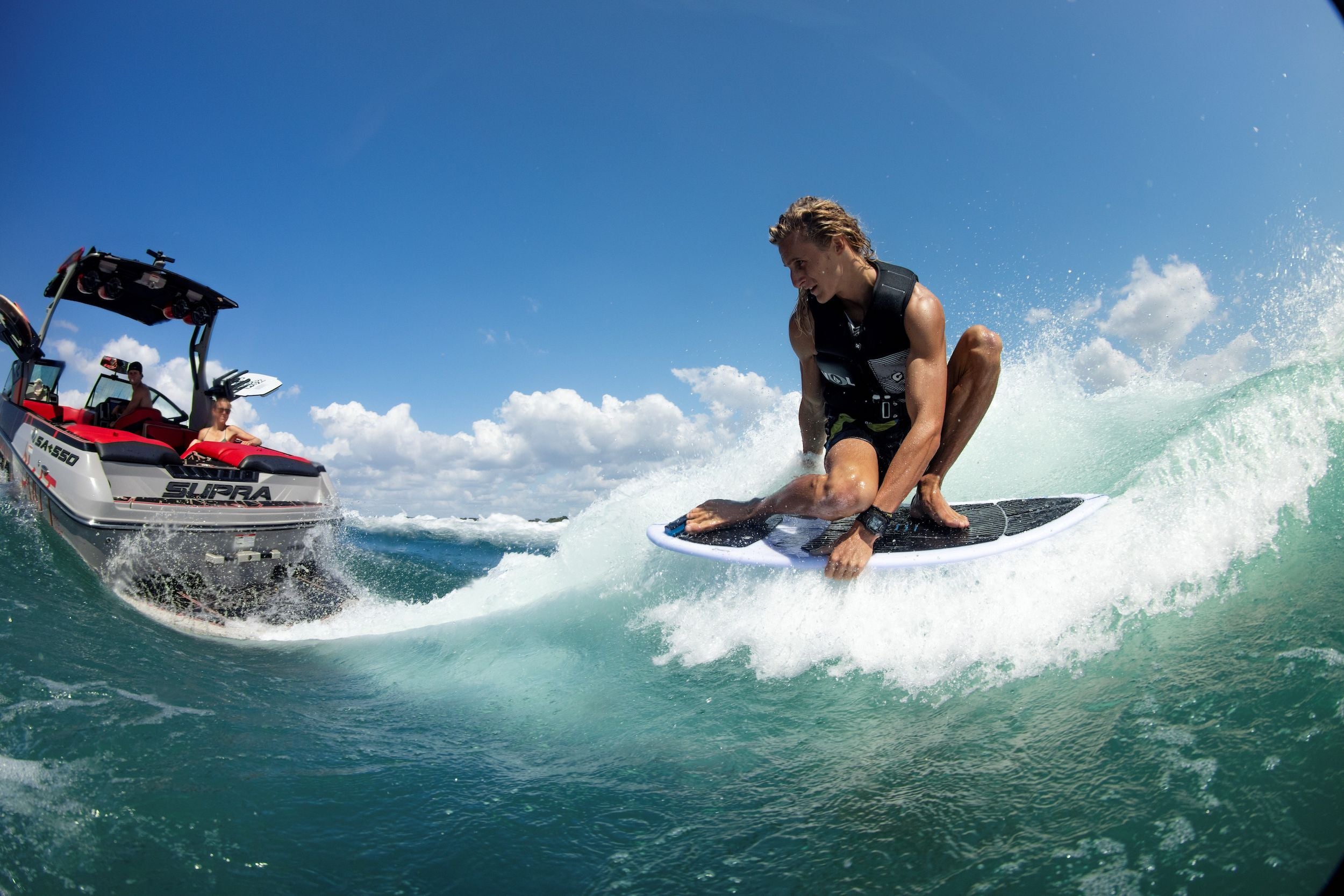 A surfer demonstrating board control while riding a wave on a Ronix 2024 Flyweight Skimmer surfboard.