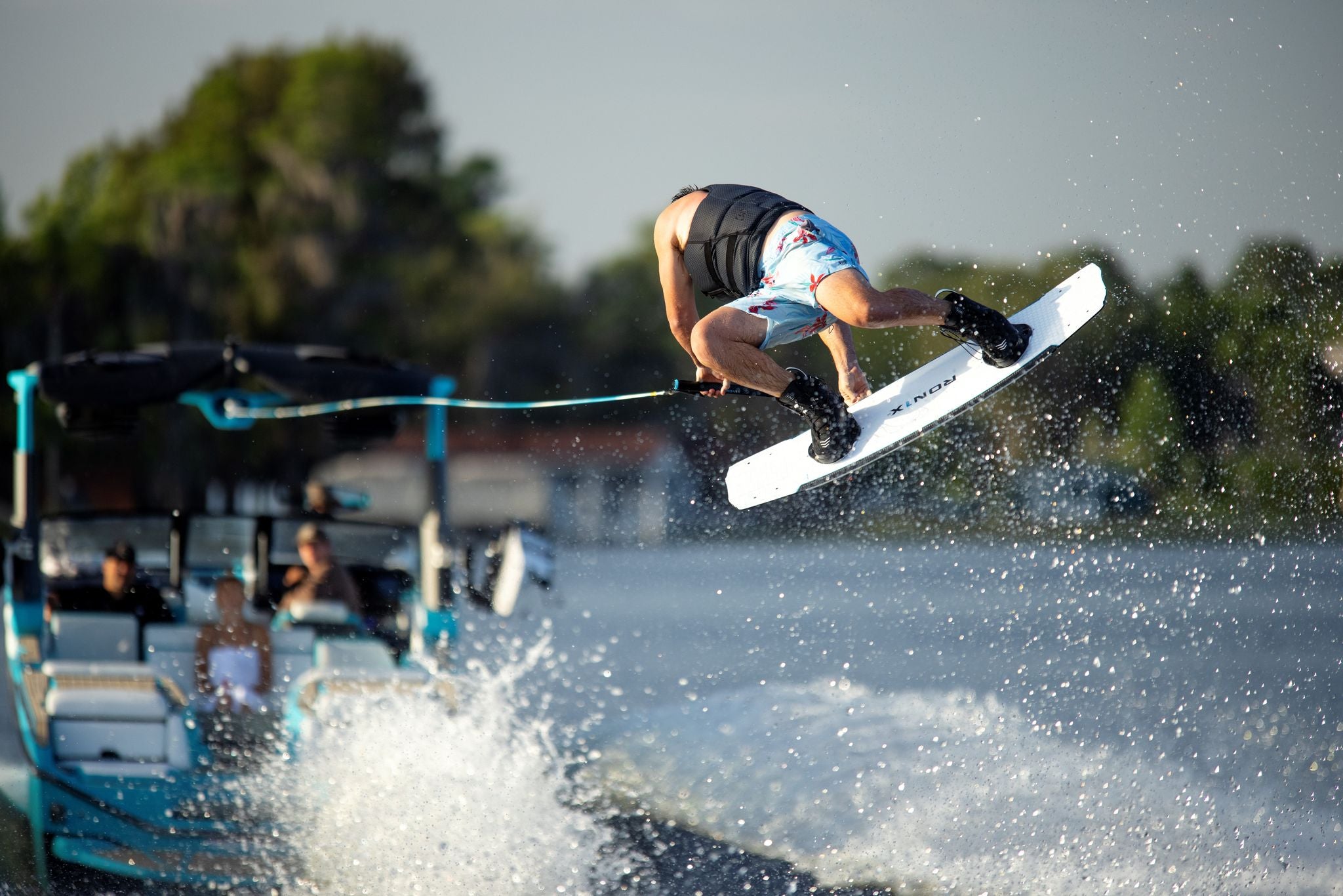 A person is doing a water ski trick while wearing the Ronix 2024 One Boots.