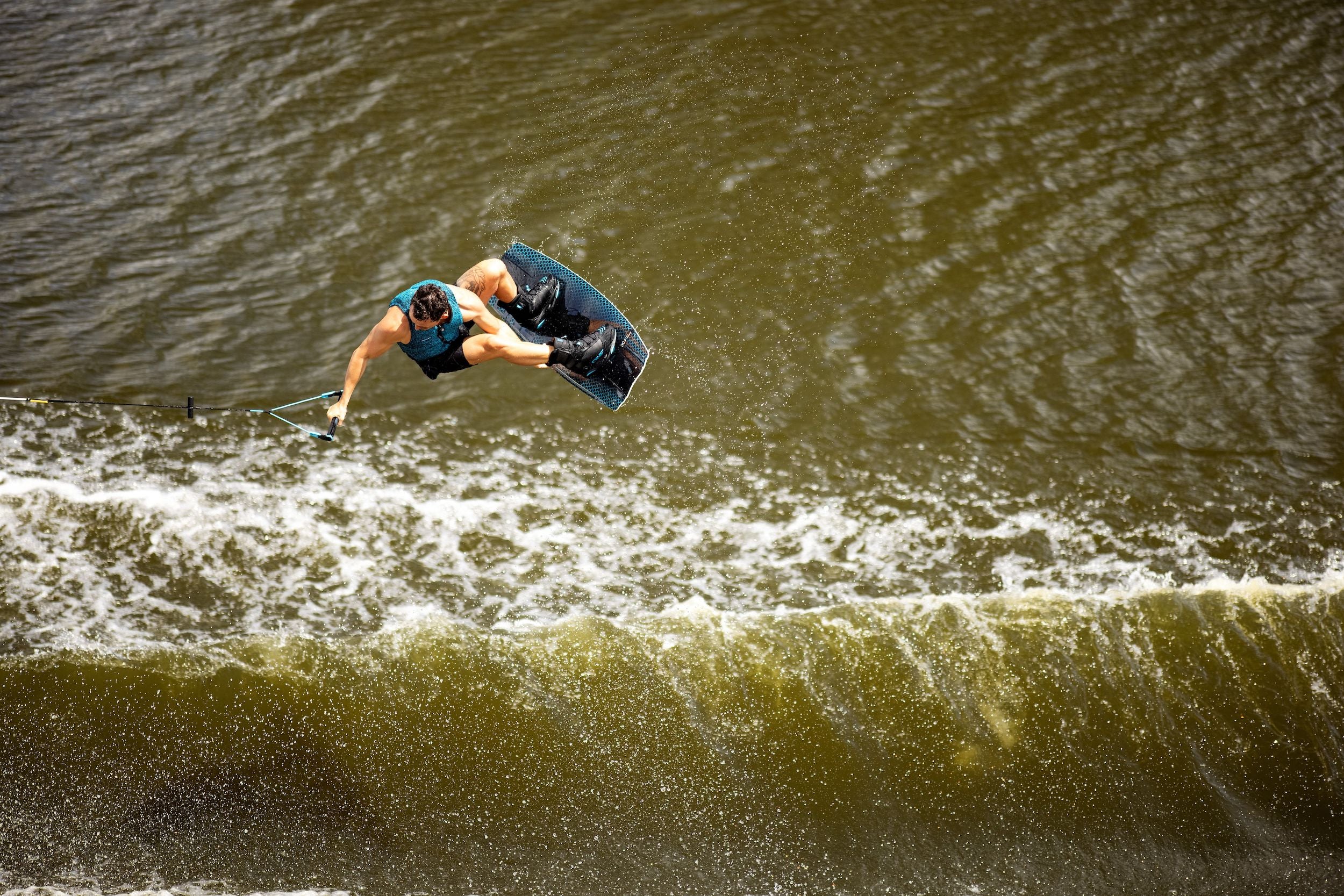 A person in the air performing a trick on a surfboard with Ronix 2023 One Carbitex Boots.
