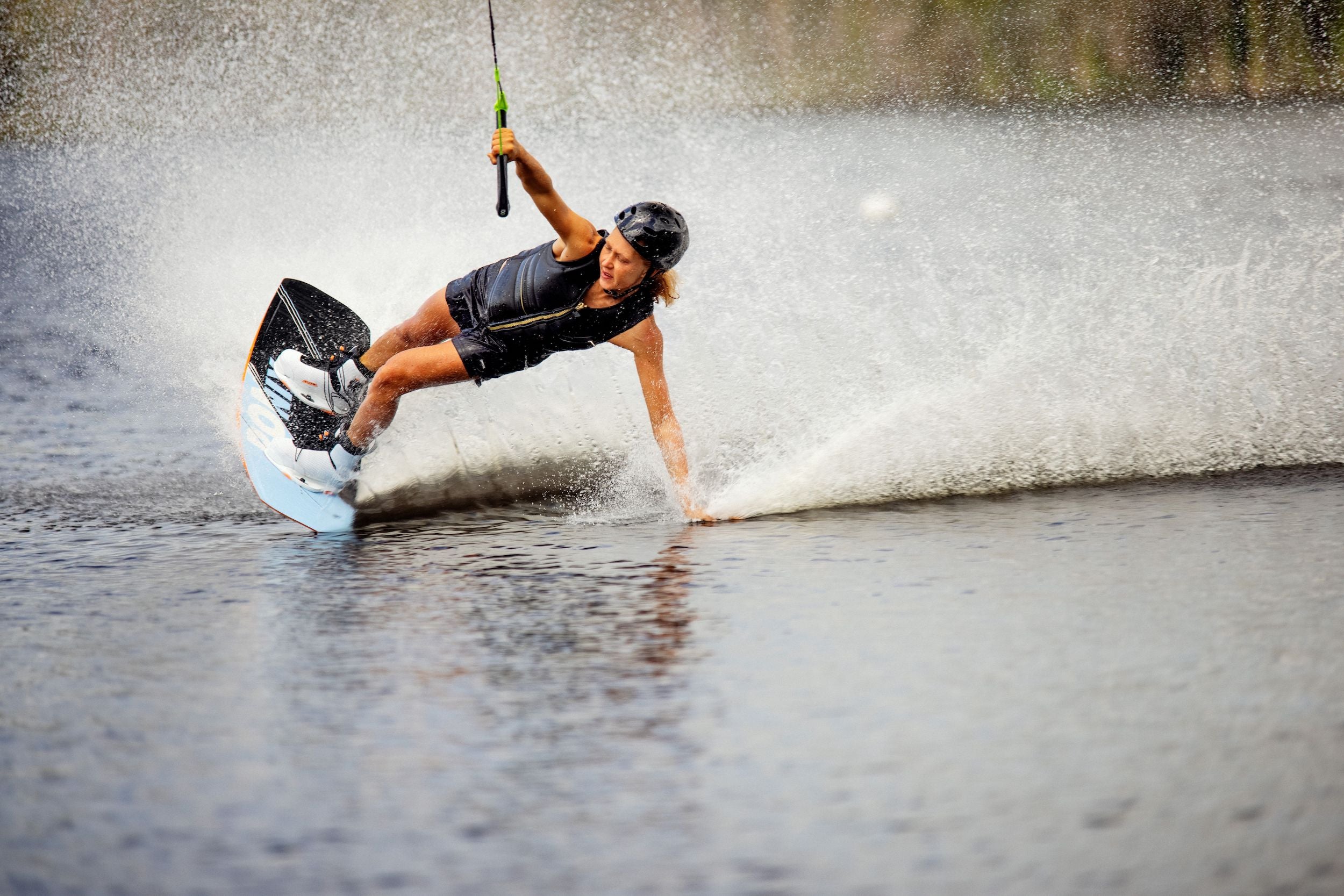 A woman is water skiing on a lake wearing the Ronix 2024 Rise Women's CE Impact Vest by Ronix and utilizing flex foam for optimum maneuverability.