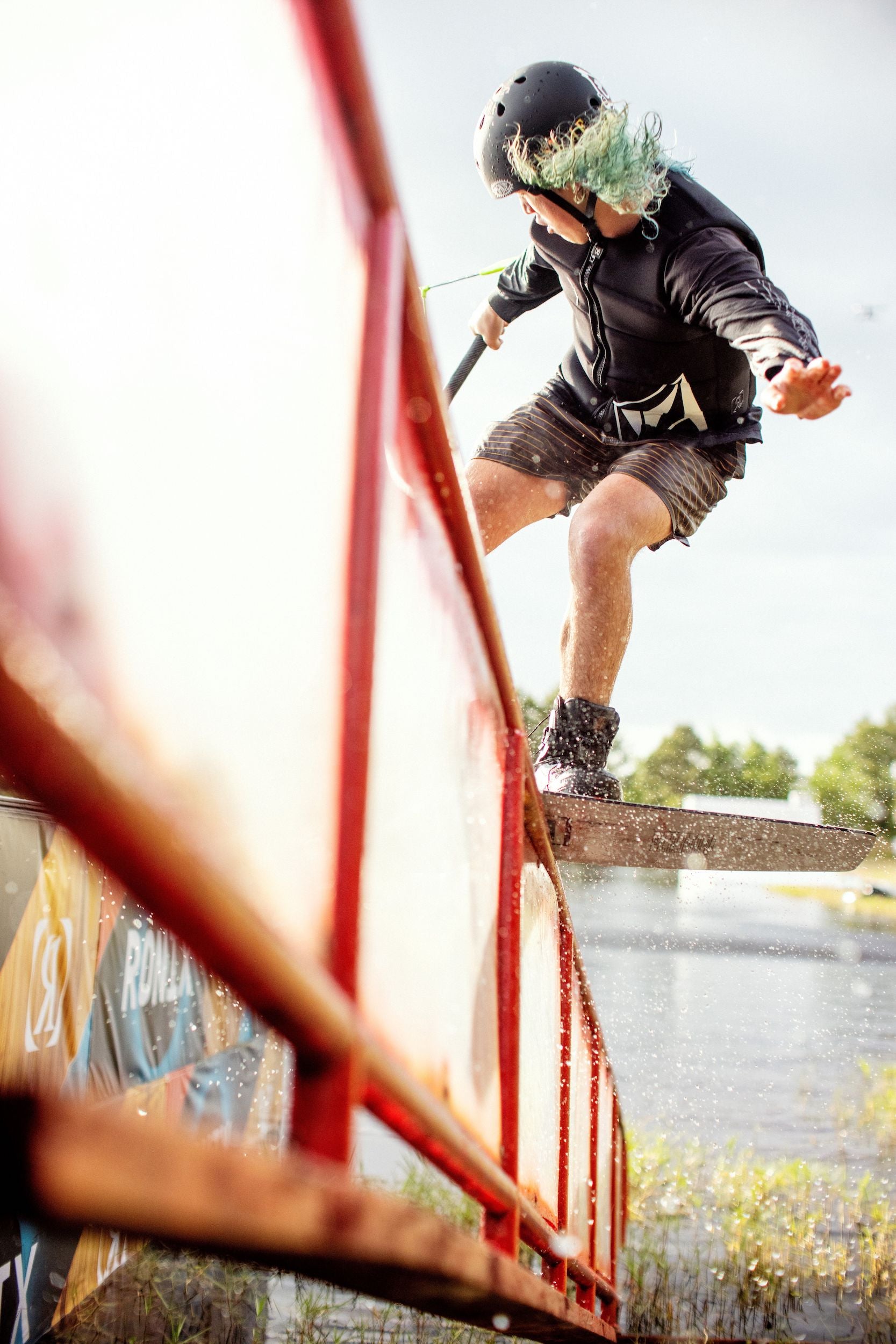 A skateboarder performing a trick on a railing while wearing a Ronix 2024 Volcom Men's CE Impact Vest.