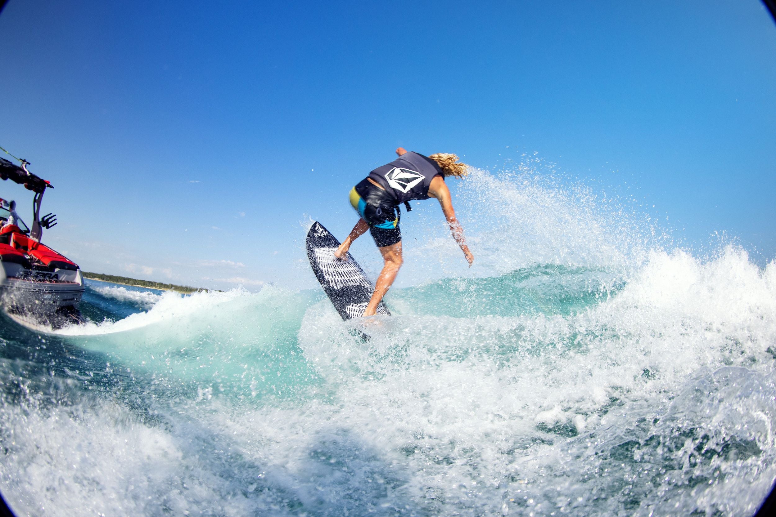 A surfer riding a wave with impeccable edge hold on the Ronix 2024 Volcom Sea Captain Wakesurf Board.