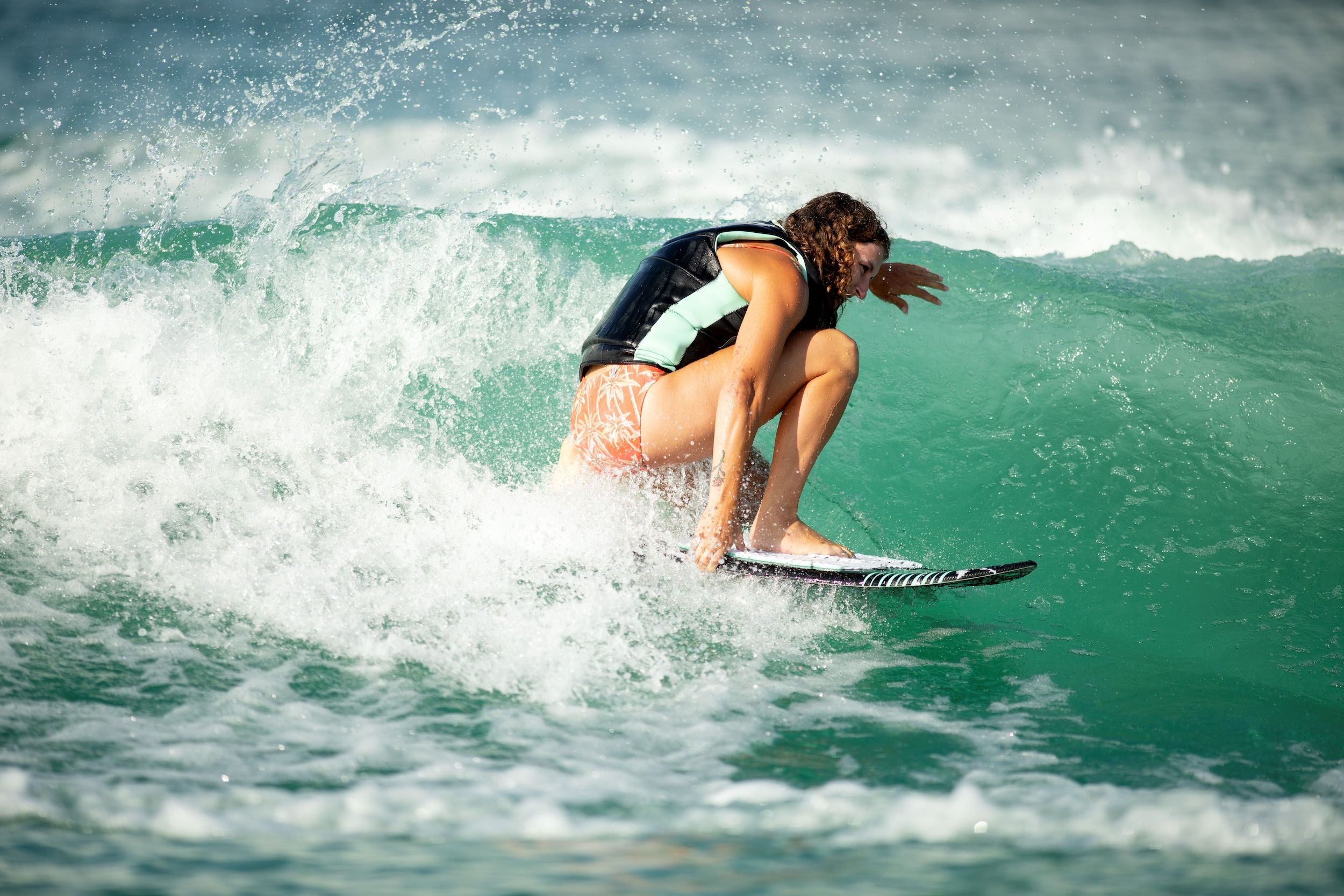 A quick-reacting surfer riding a wave on a Ronix 2024 Women's Sea Captain wakesurf board.