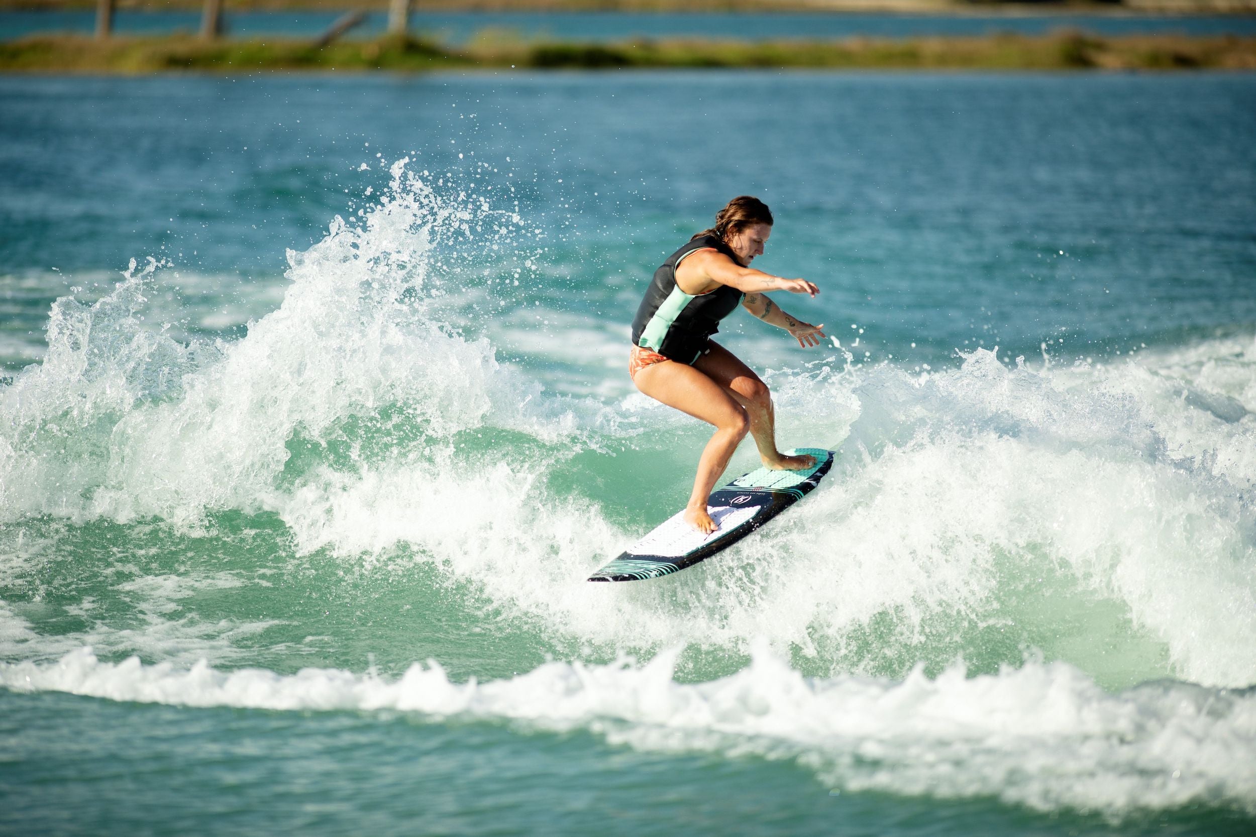 A surfer quickly reacting on a wave with the Ronix 2024 Women's Sea Captain Wakesurf Board by Ronix.