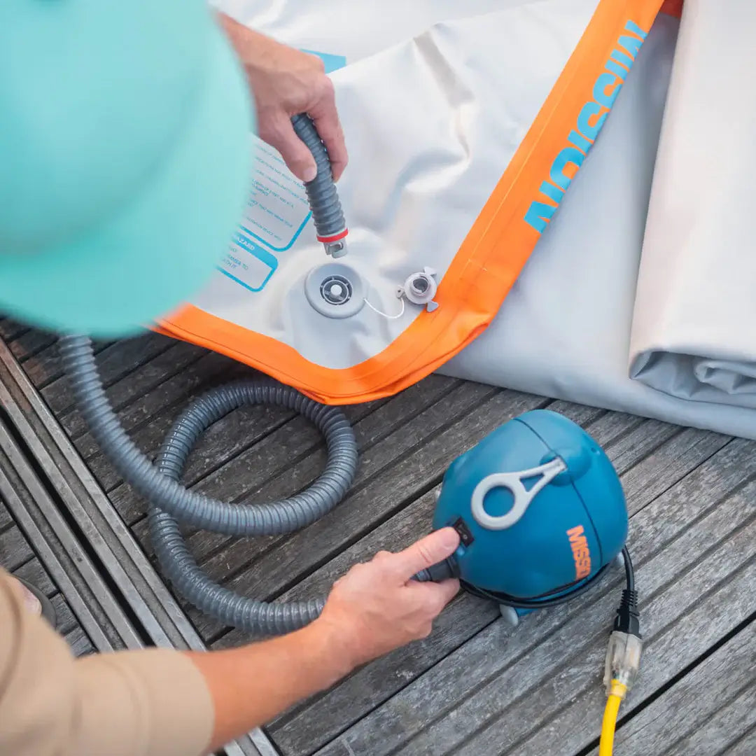 A person is using a MISSION 120V Electric Pump 3.6psi to clean an inflatable boat.